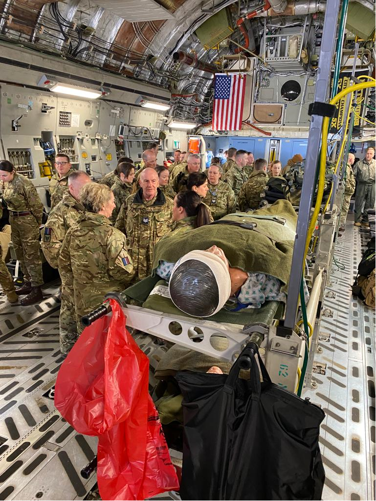 Personnel inside C-17 carrier, with dummy patient and other medical equipment.
