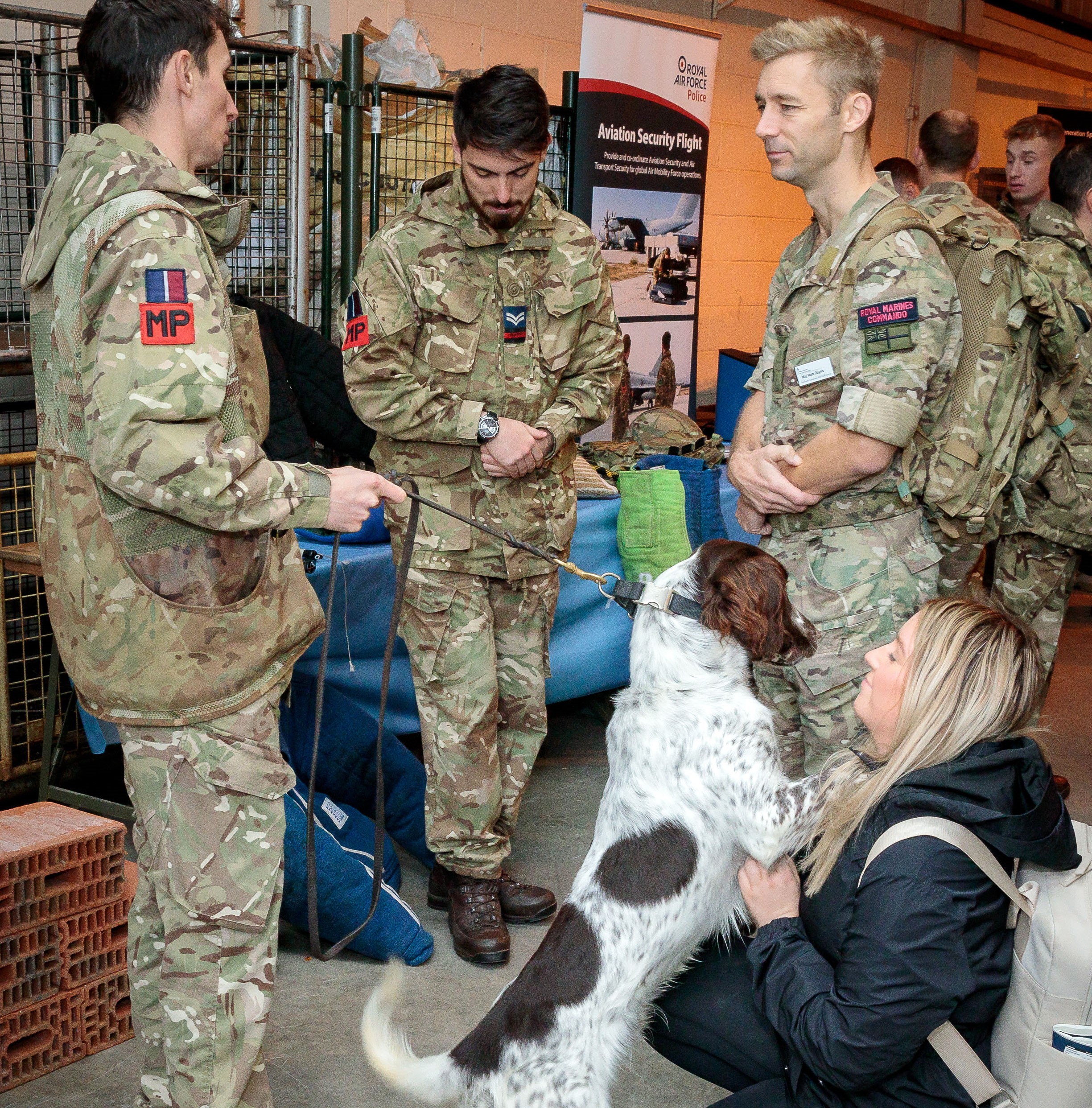 Image shows RAF Police with military working dog greeting civilian.
