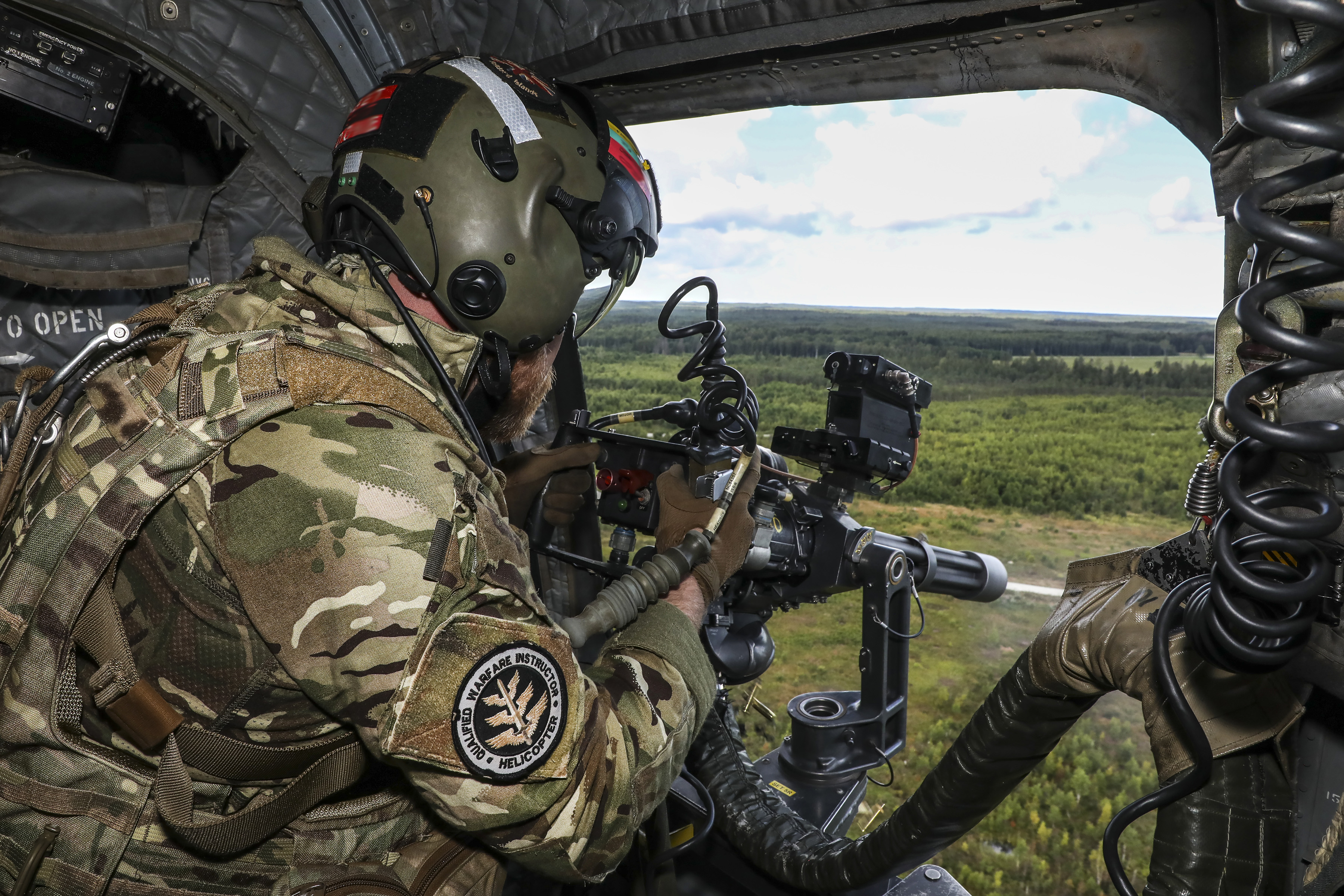Image shows RAF Regiment Gunner looking out from Chinook.