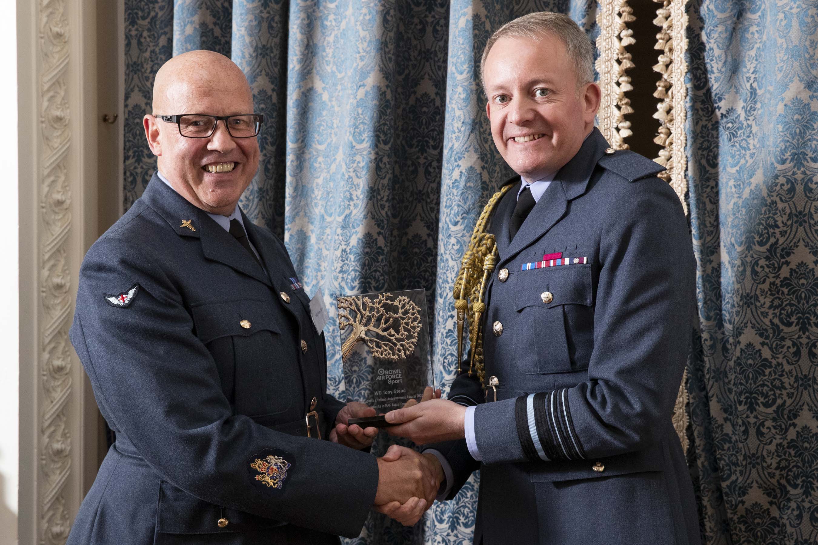 Image shows RAF personnel holding glass award.