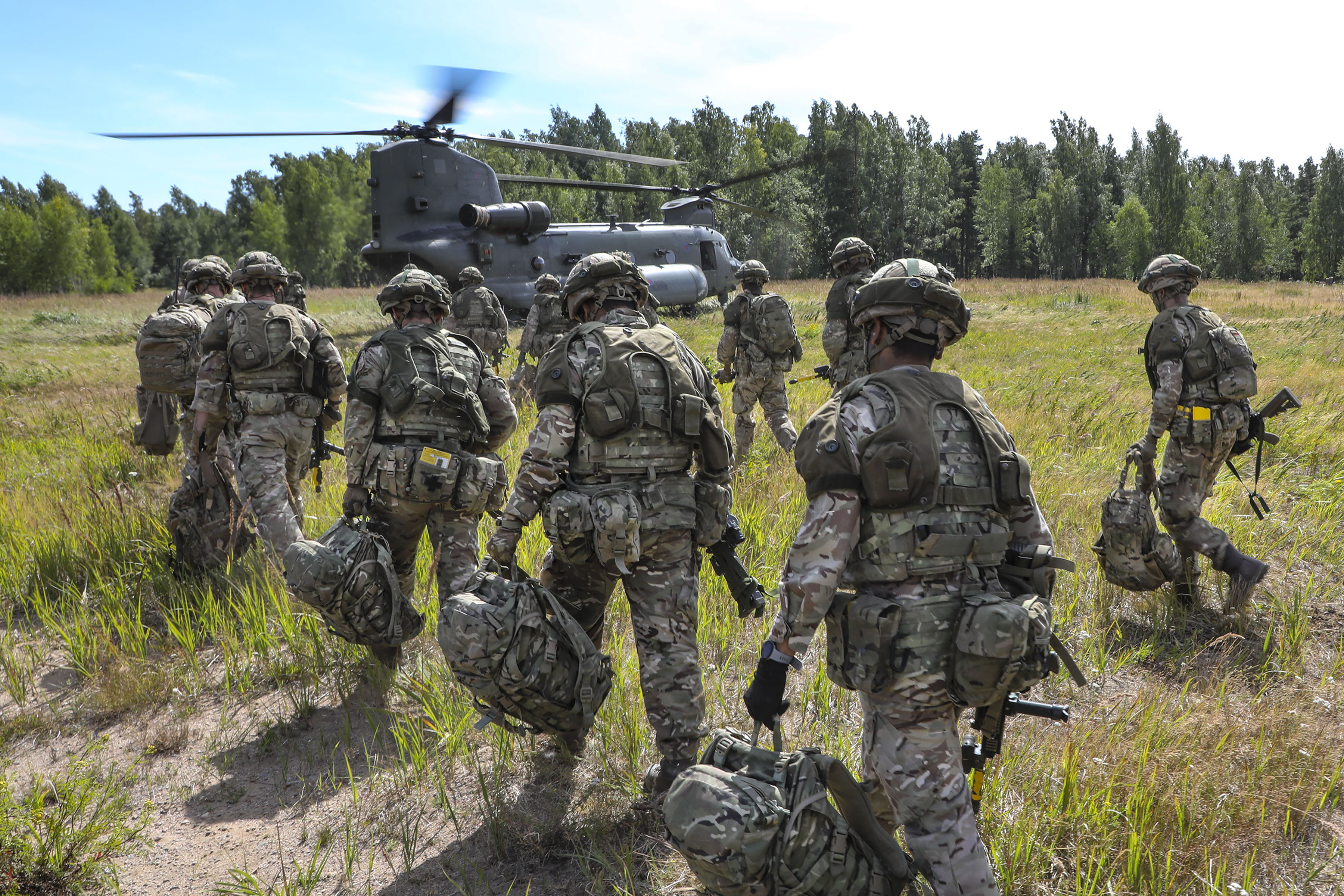 Image shows RAF Regiment walking towards Chinook with baggage and rifles.