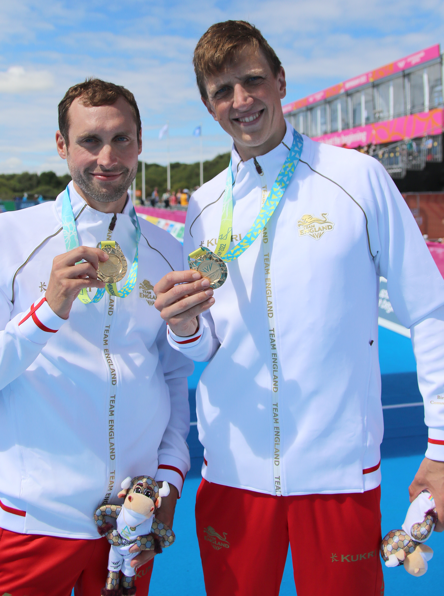 Image shows sportsmen holding gold medals.