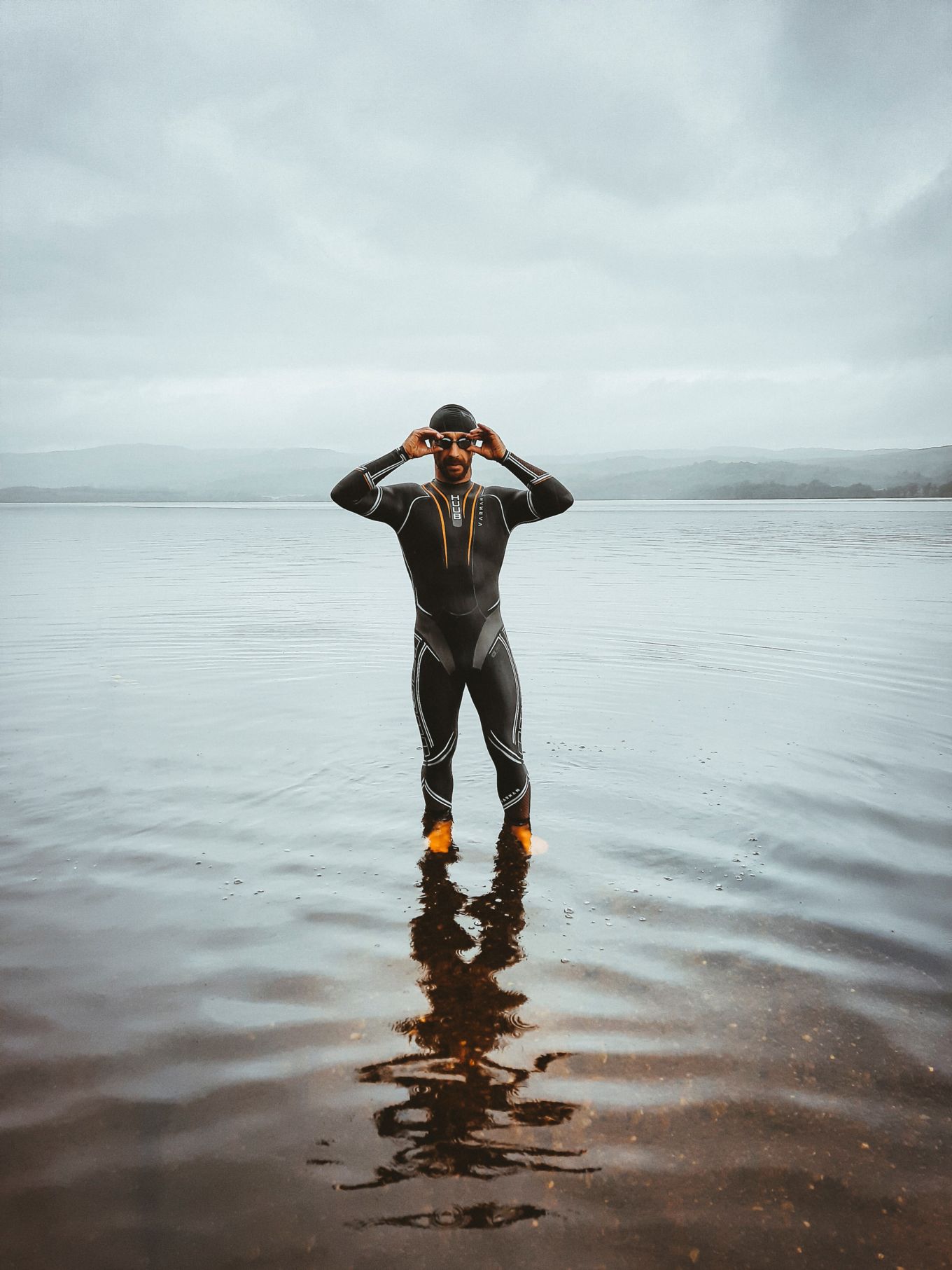 Swimmer stands in a lake.