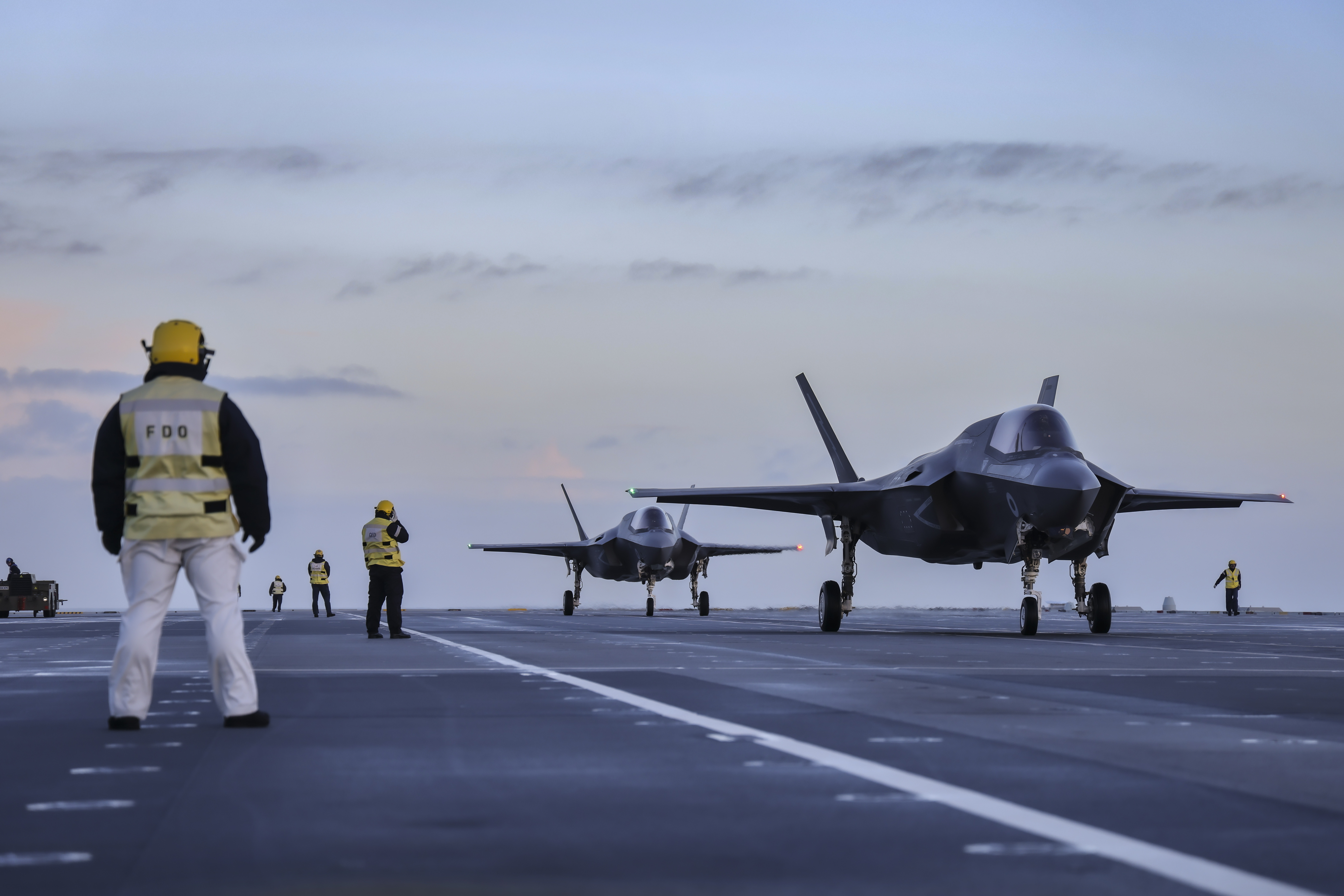 Image shows personnel and RAF Typhoons on the deck of aircraft carrier.