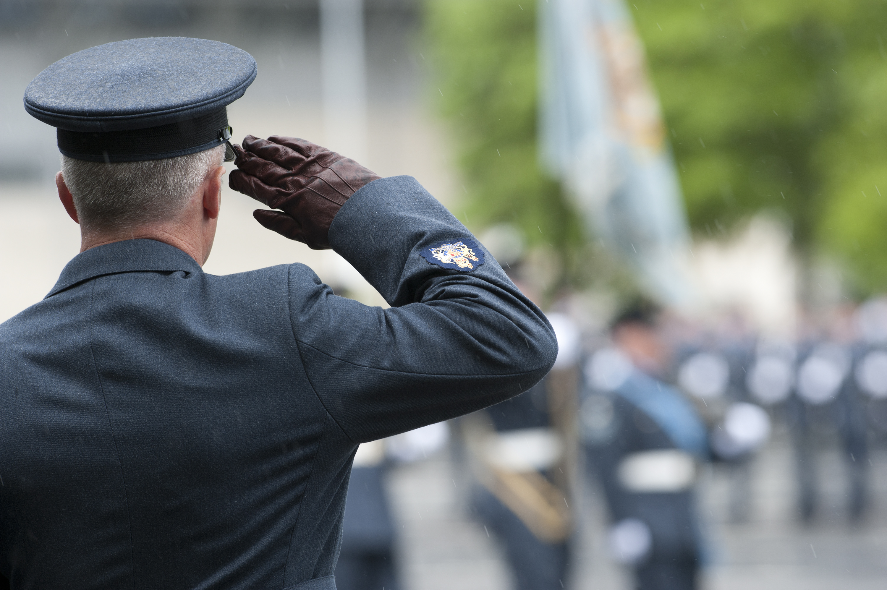 Personnel salutes, background is blurred out.