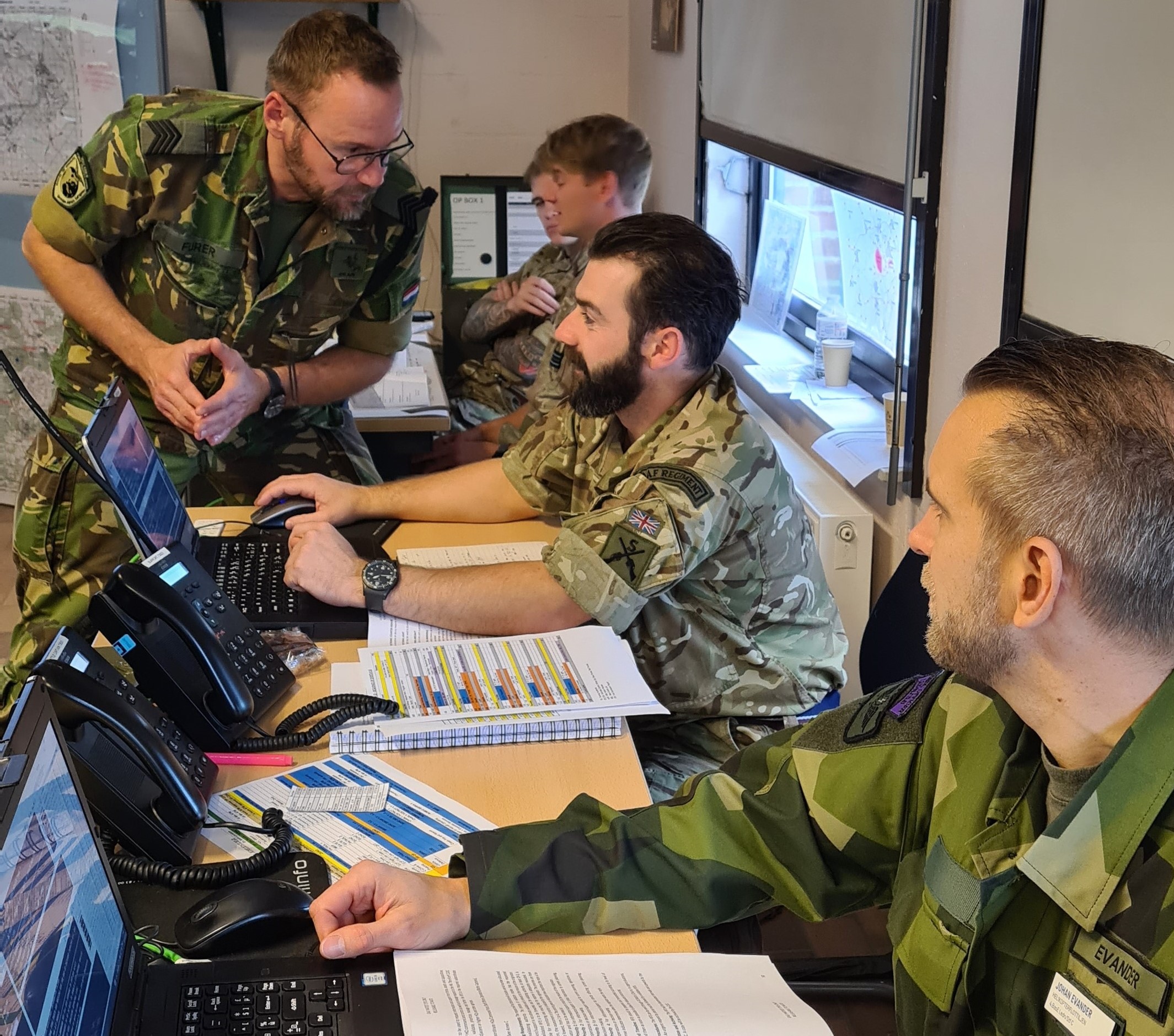 Image shows RAF personnel working at a table with computer. 