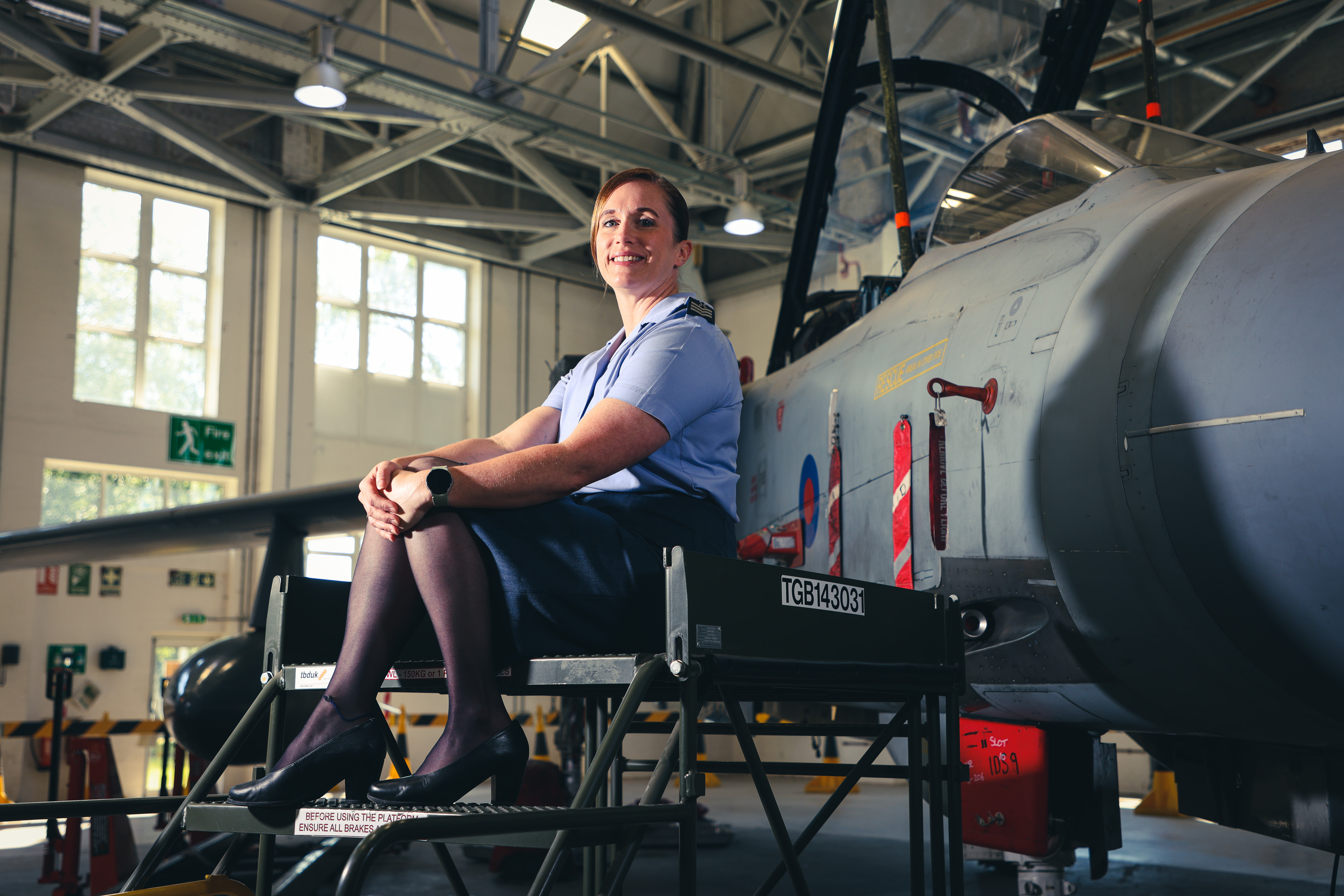 Chief Technician Morgan in RAF uniform in front of a RAF aircraft in a hangar