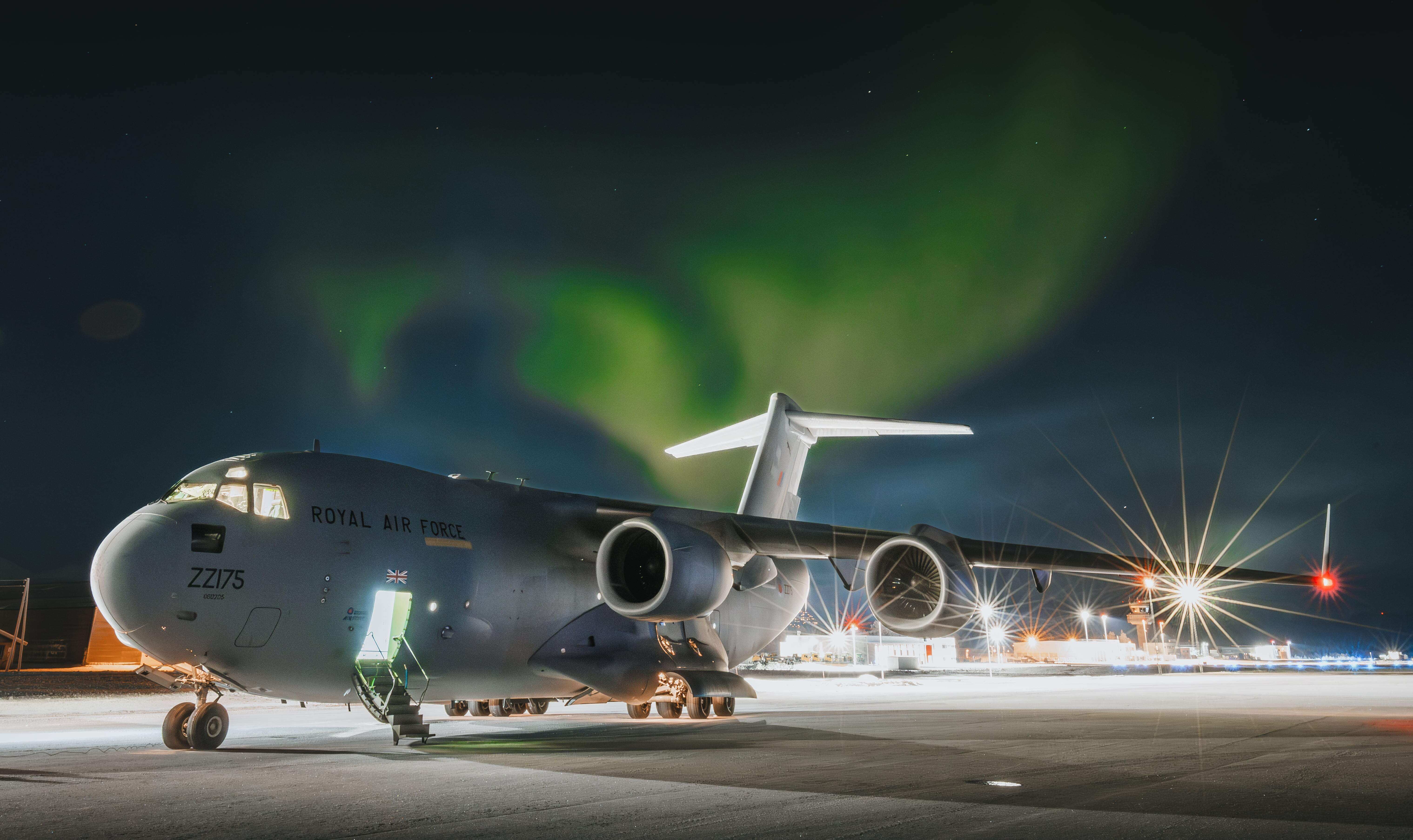 C-17 aircraft on runway at night with backdrop of the Northern Lights
