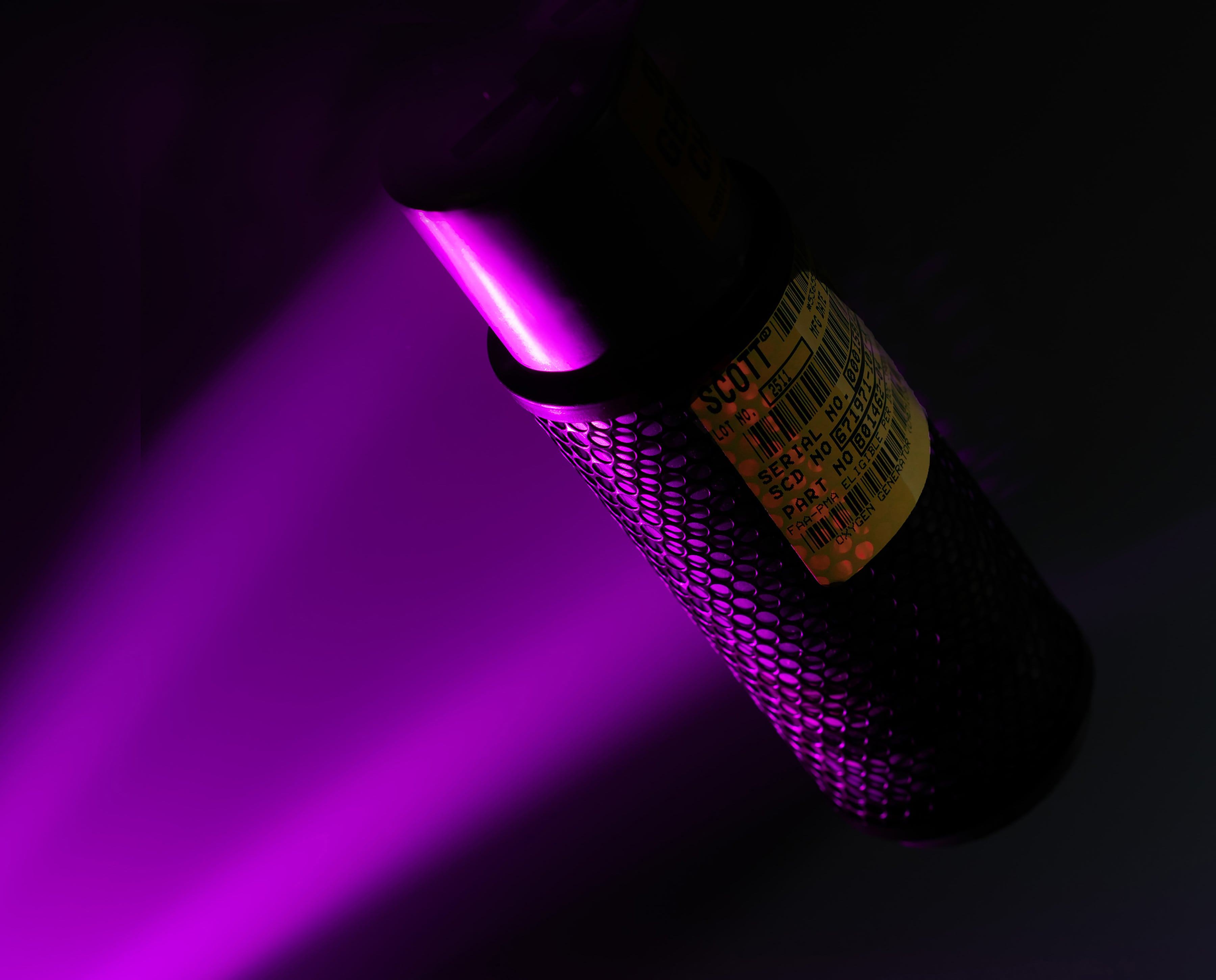 Close up of a small piece of equipment highlighted in purple light