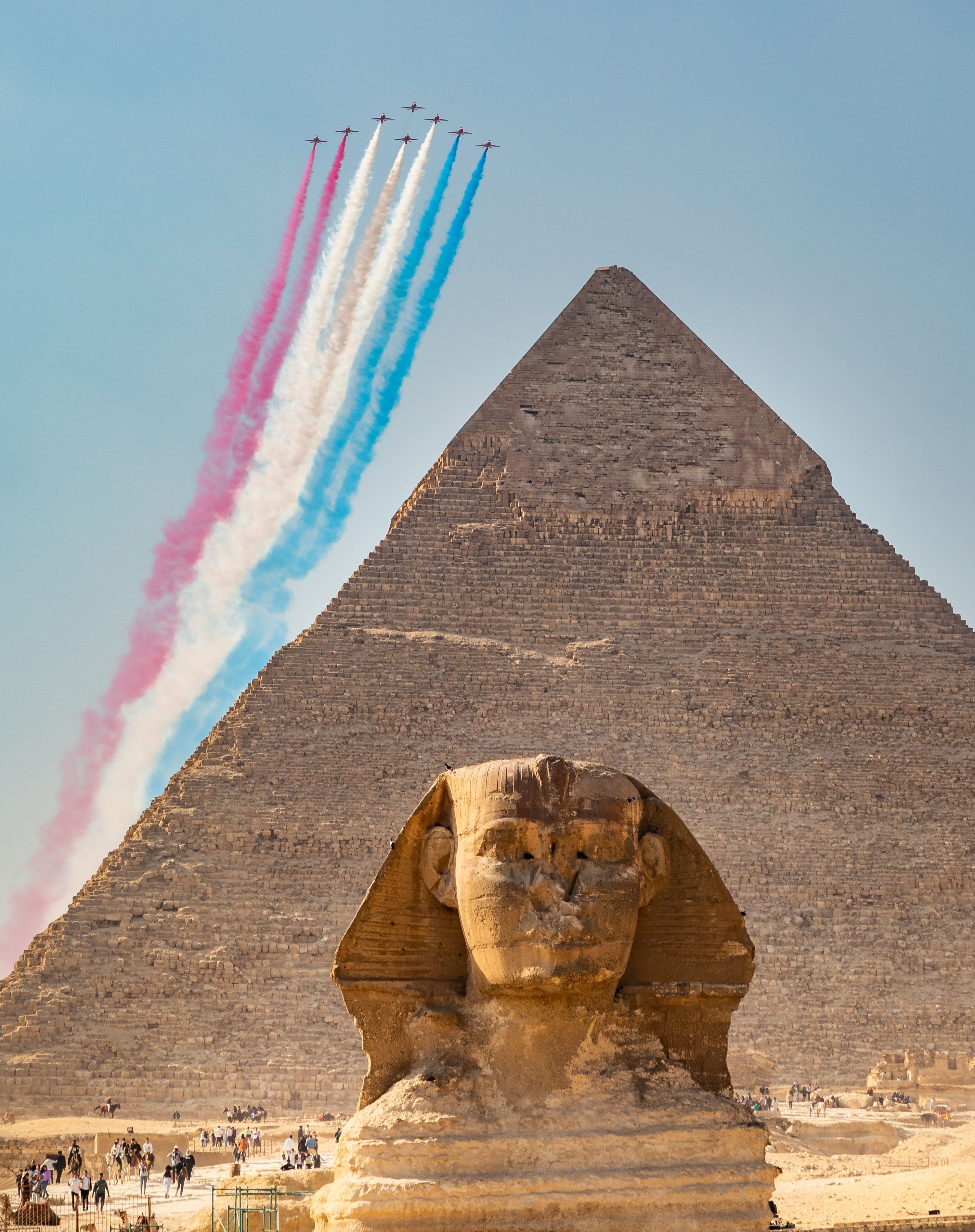 Red Arrows flying with smoke on above the pyramids