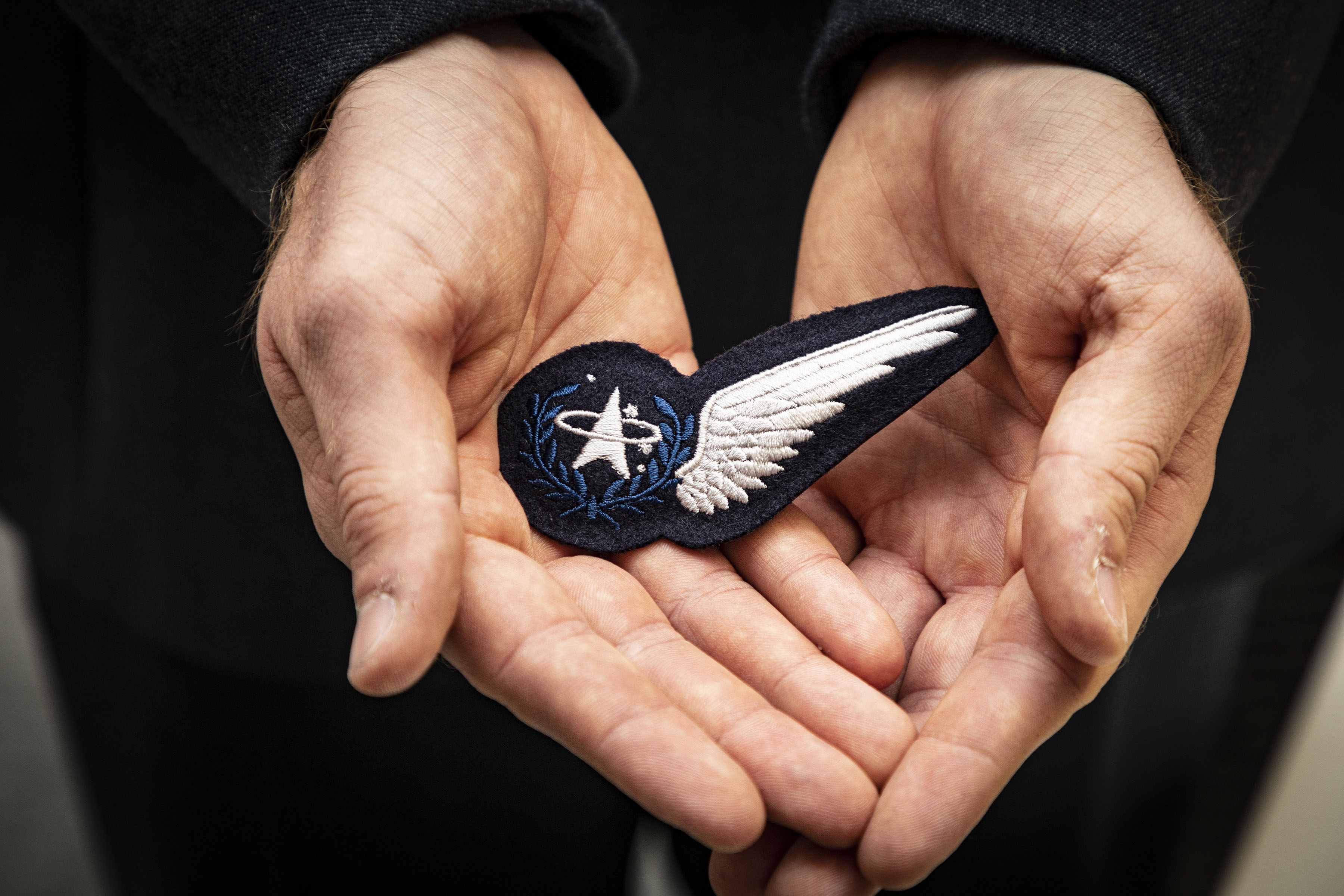 Space Command badge cradled in someones hands