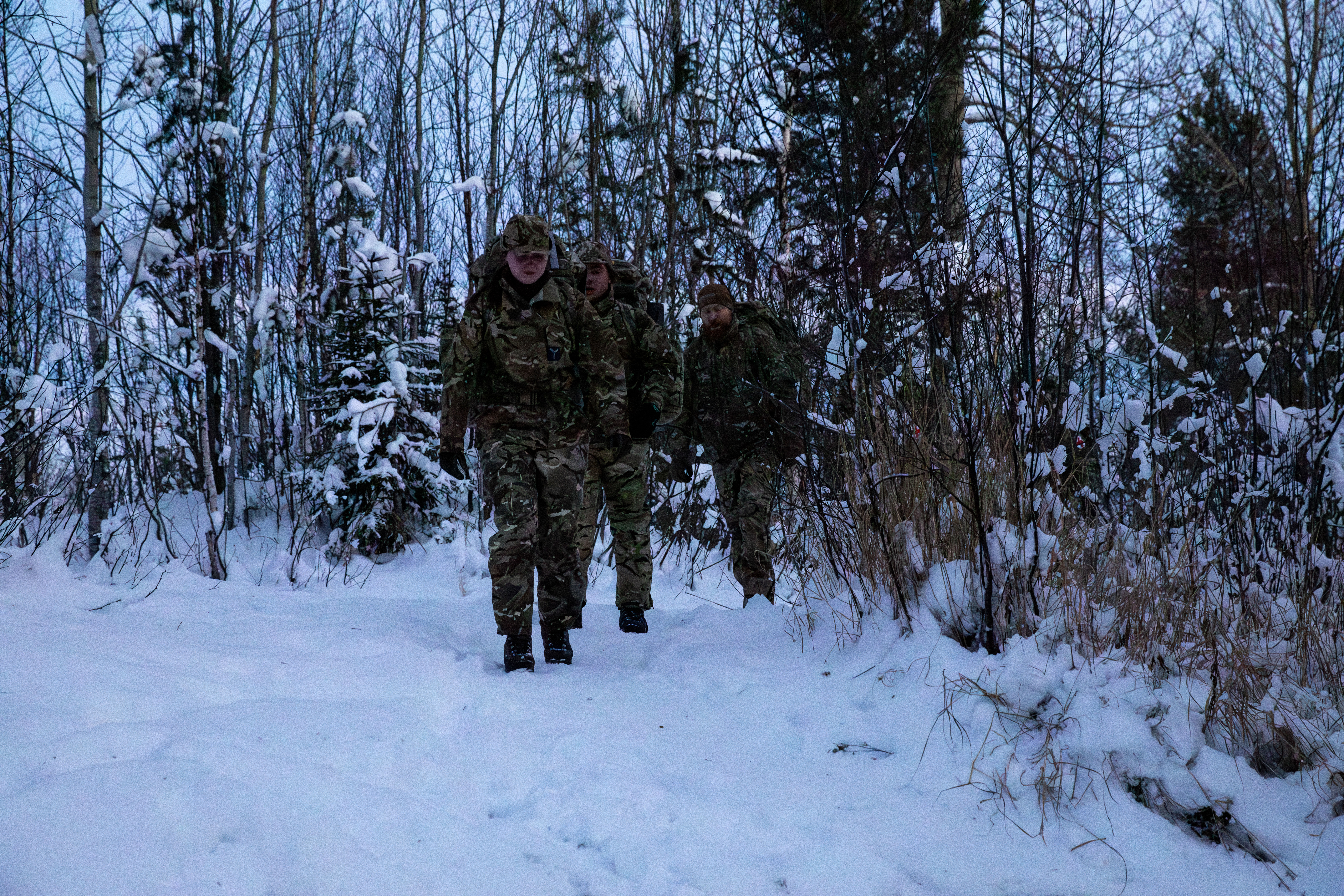 RAF personnel walking through snow and trees