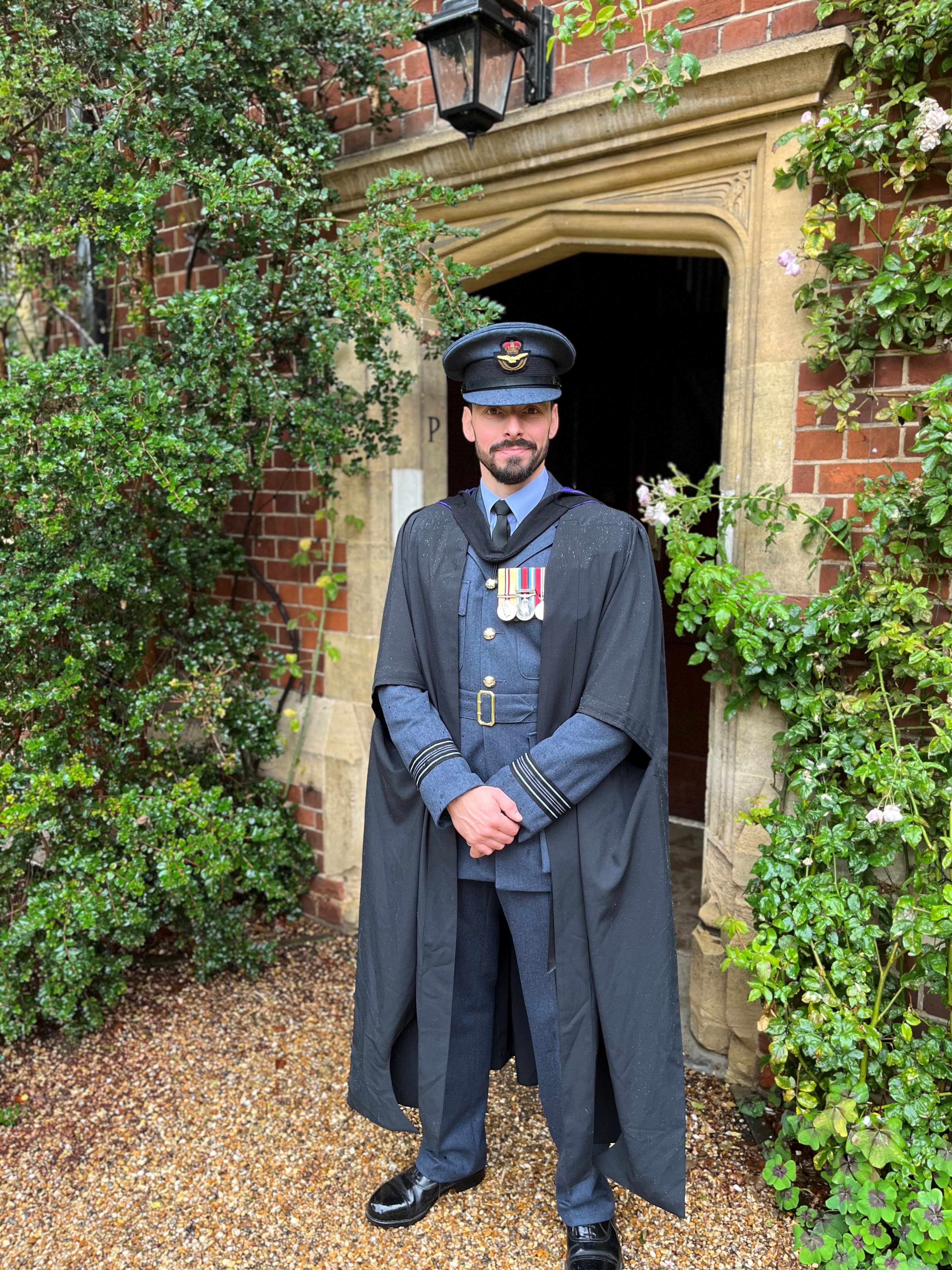 Squadron Leader Handley dressed in his cap and gown over his RAF uniform for graduation
