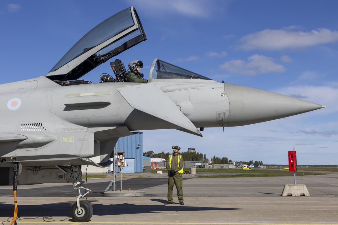 Typhoon aircraft parked on runway with cockpit open and engineer stood beneath the aircraft