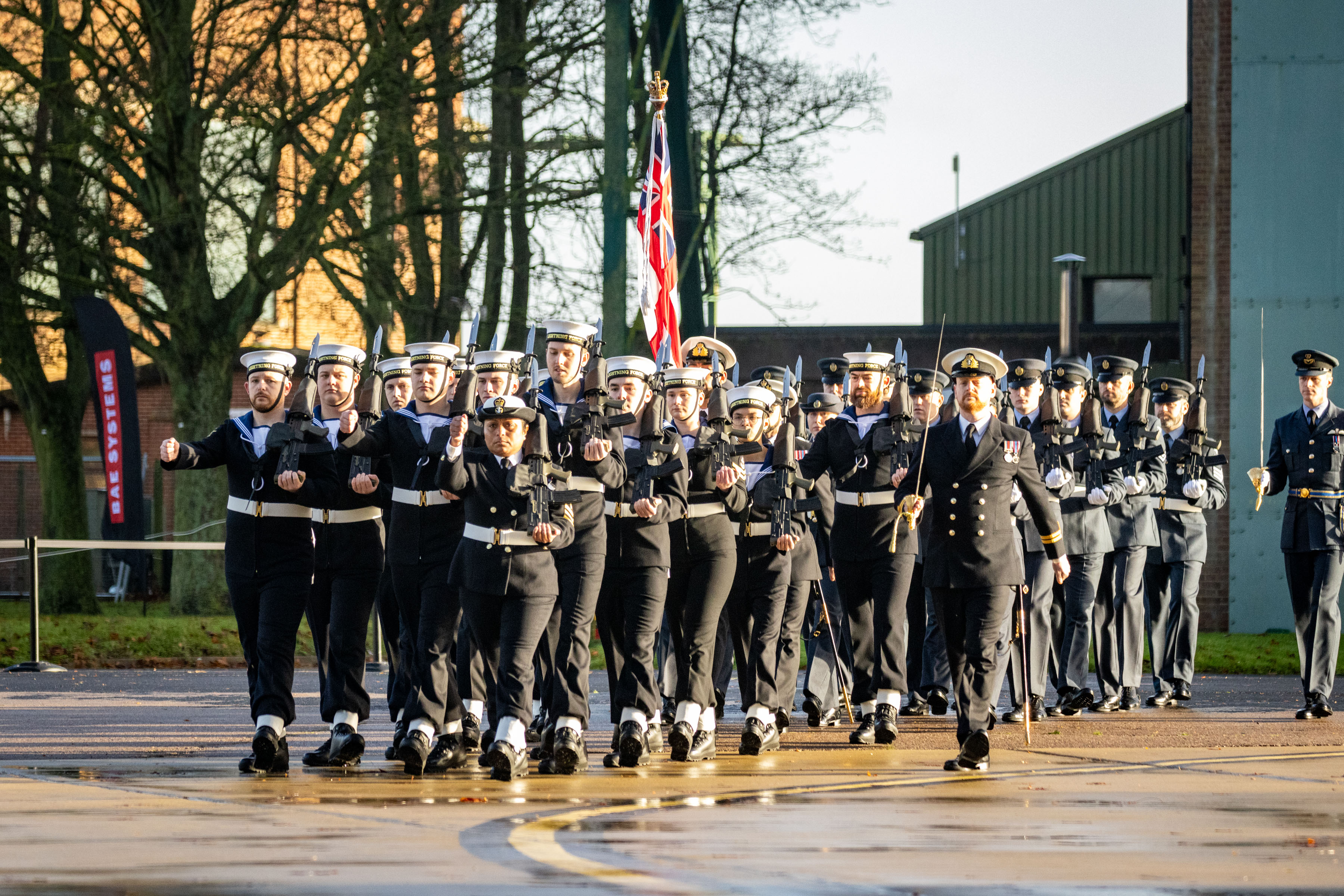 Royal Navy and RAF personnel marching on parade.