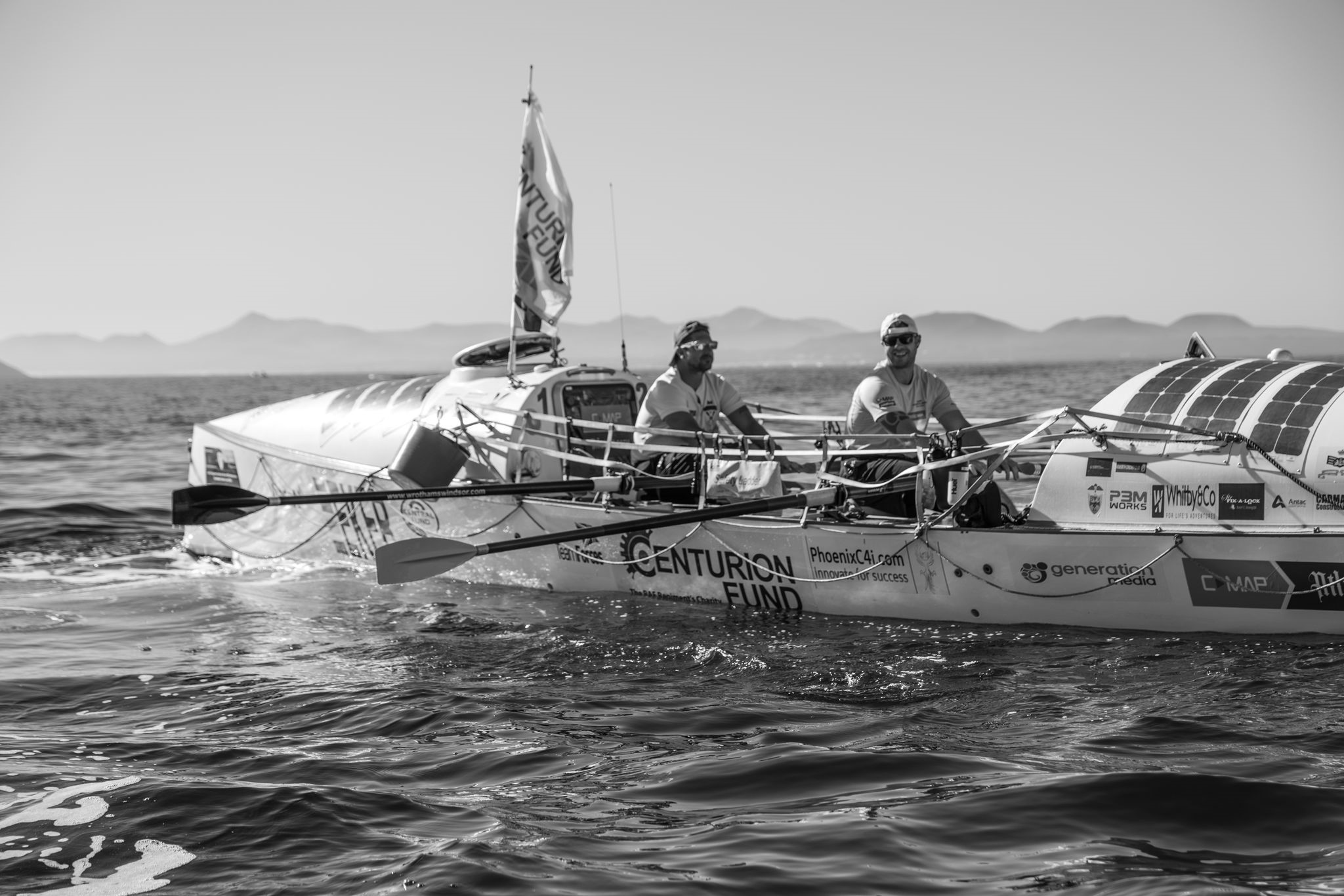 Black and white photo of the crew on the boat in the ocean.