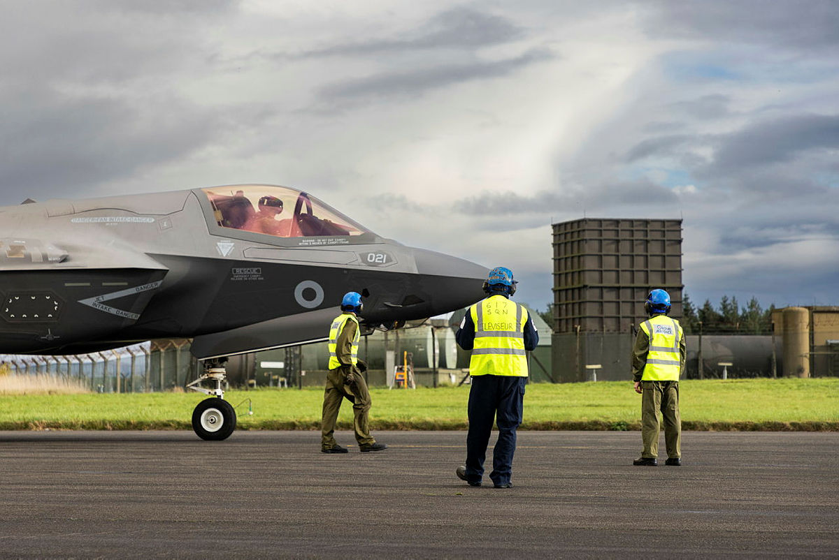 F-35 aircraft on runway with engineers in the foreground