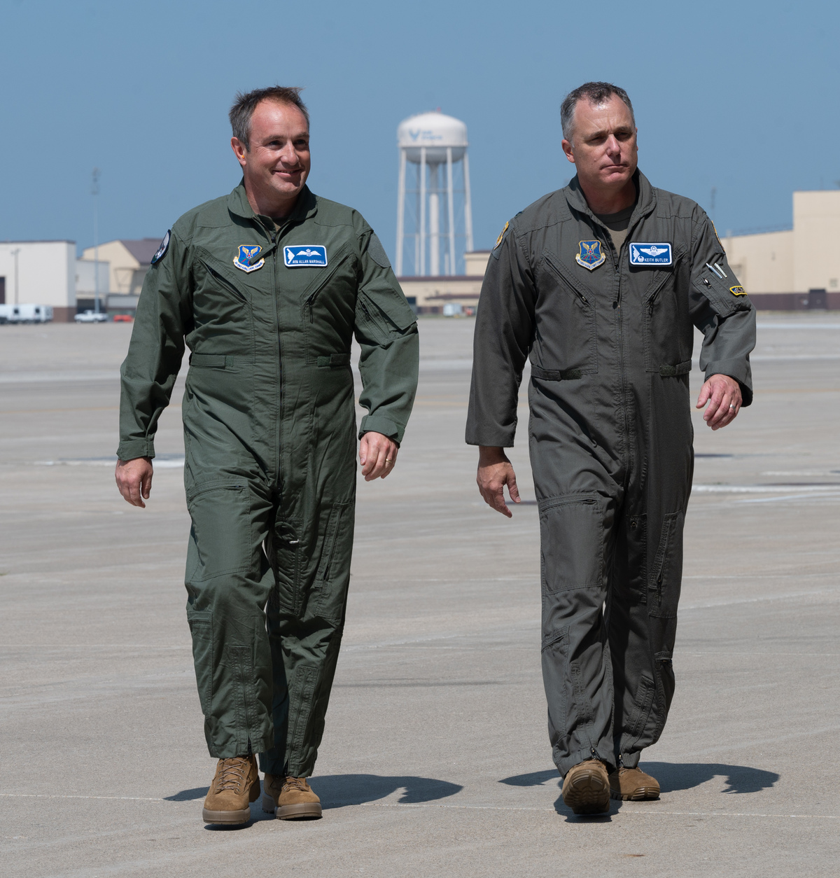 Marshall (left) and Butler (right) walk across the flight line
