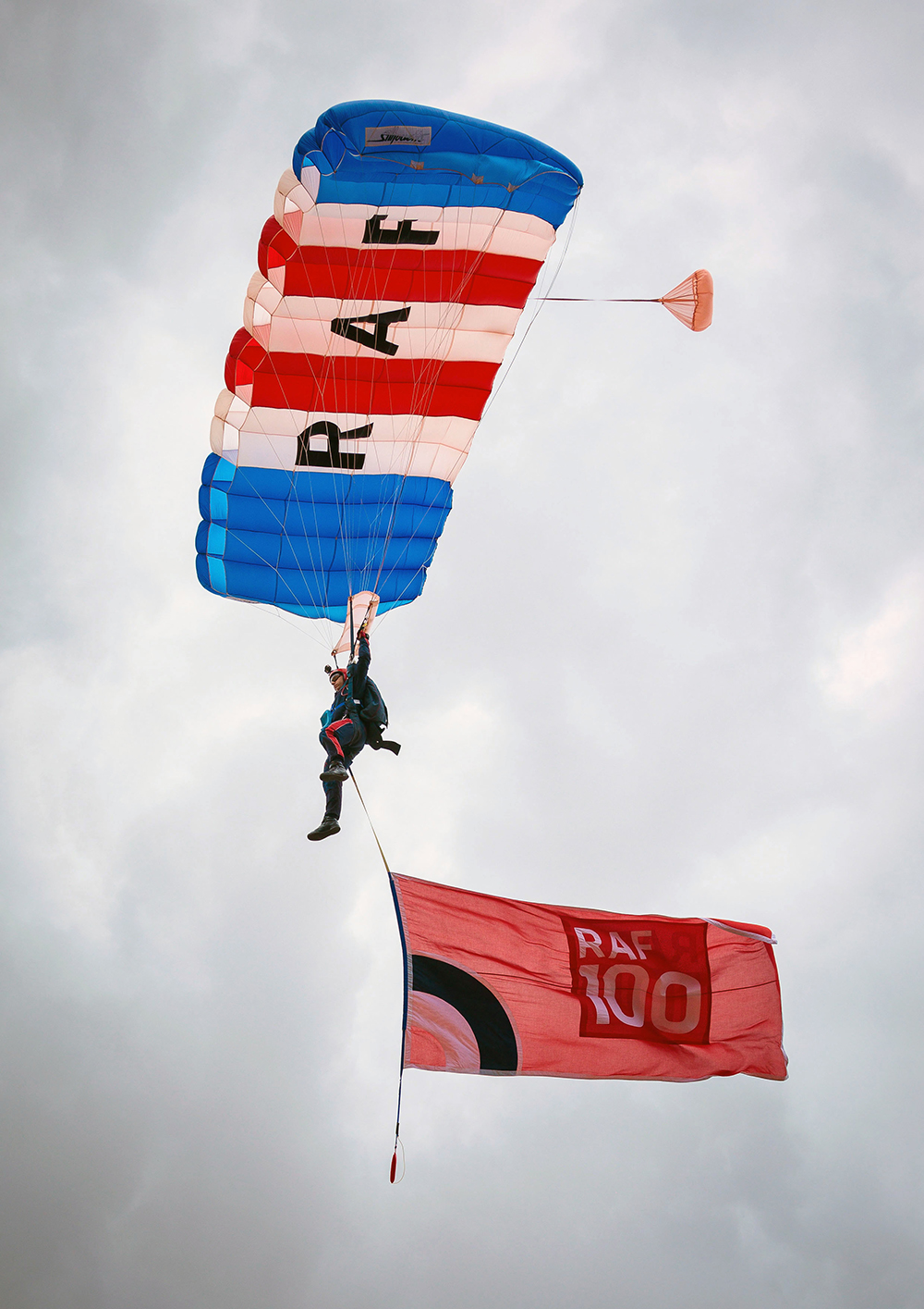 Sergeant Lee Coonan, Second Year Falcon jumps with the RAF ensign at Carterton Community College on 17th July 2018 to mark the end of the RAF100 STEM challenge