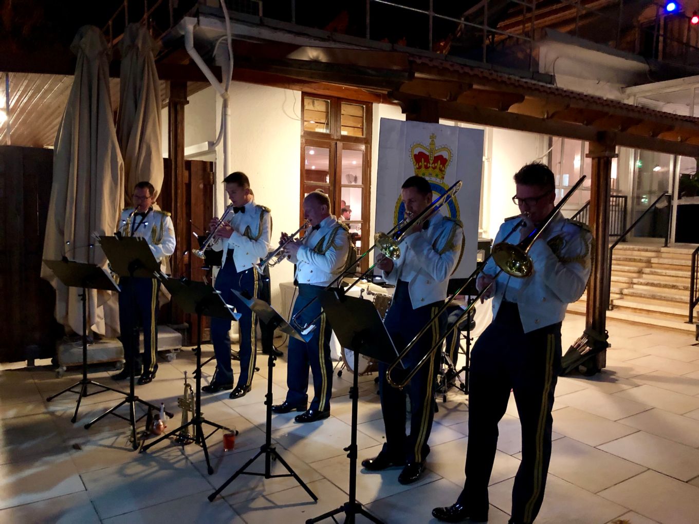 A uniformed brass quintet playing music.