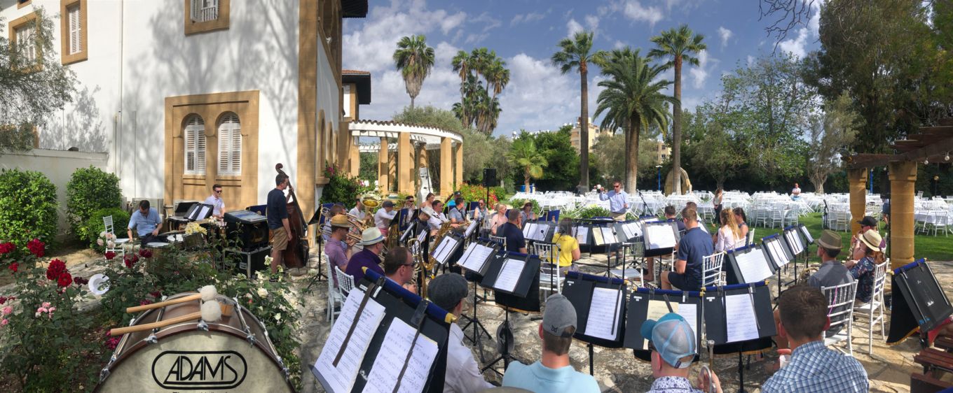 Windband plays music in picturesque gardens.