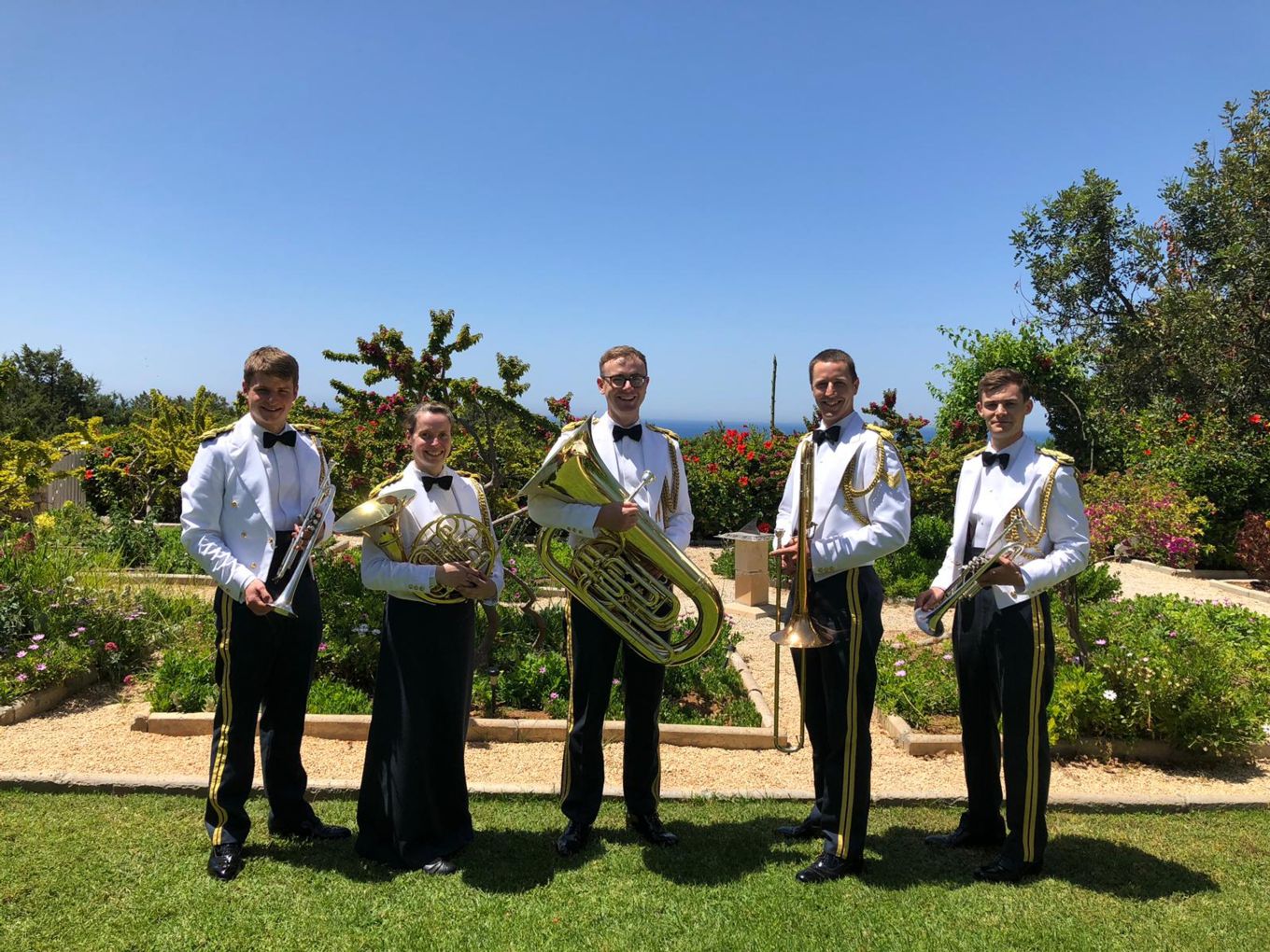Uniformed brass quintet pose for a photograph.
