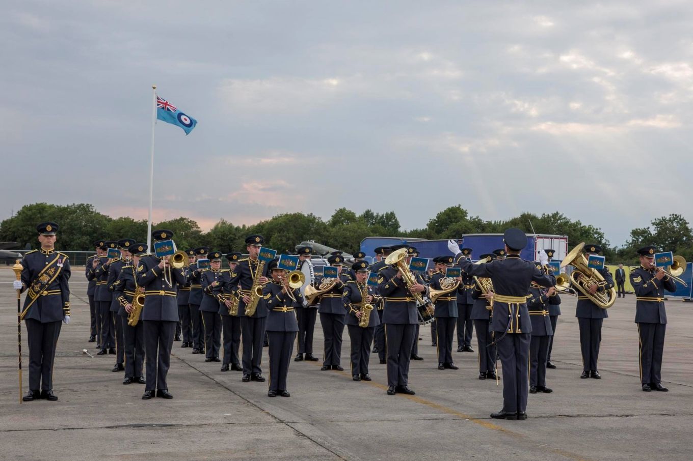 Band of the RAF Regiment play music with the RAF ensign flying above.