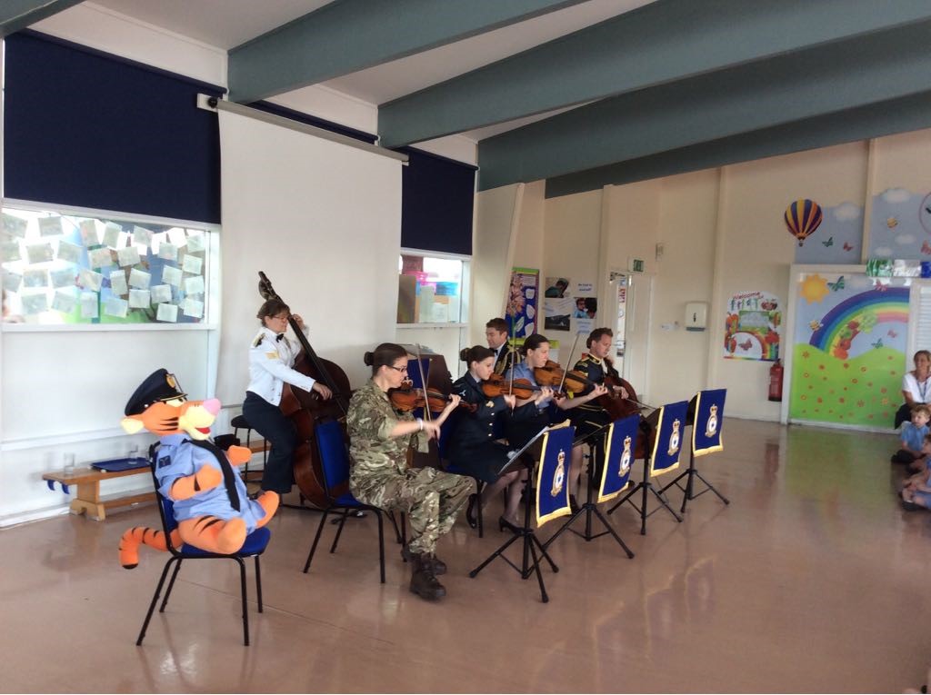 Uniformed musicians play music in a school hall.