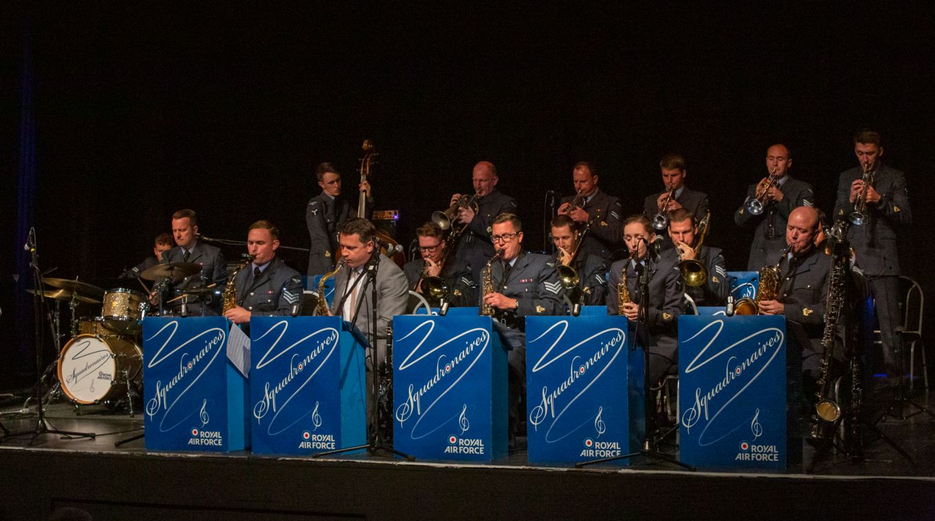 RAF Squadronaires play music at a concert-hall.