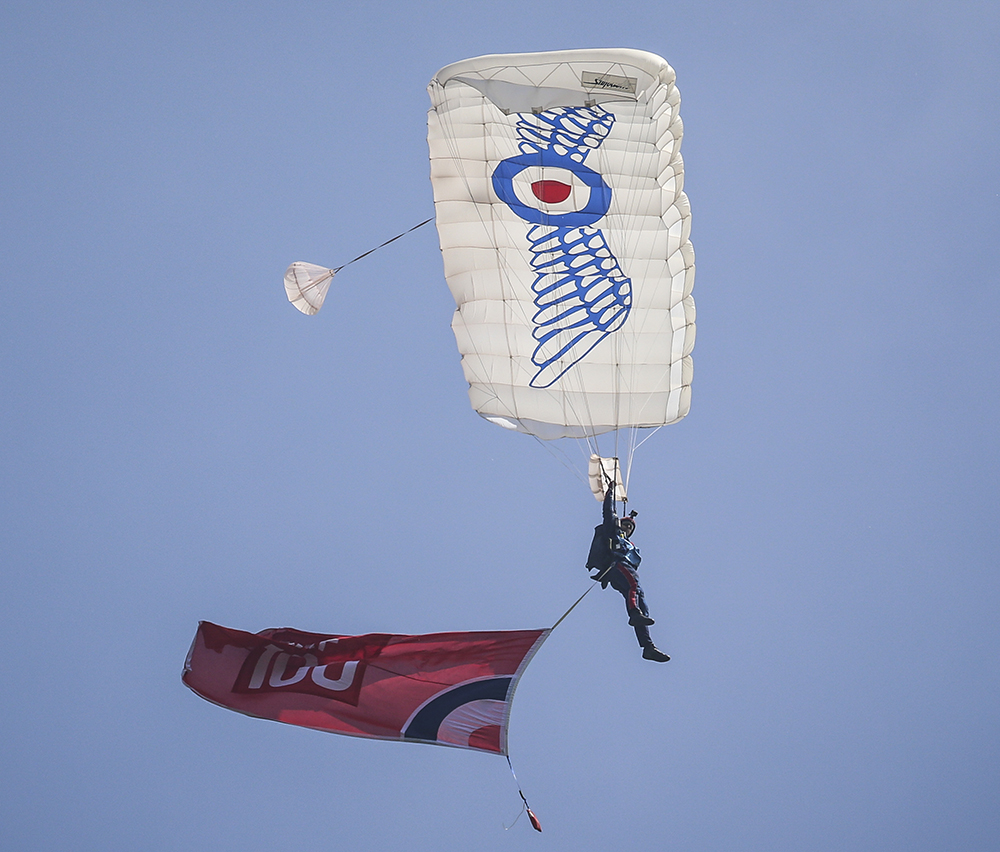 The RAF Falcons proudly jump with the RAF100 flag