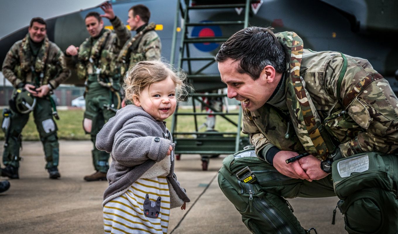 Image shows an RAF pilot with a little girl.