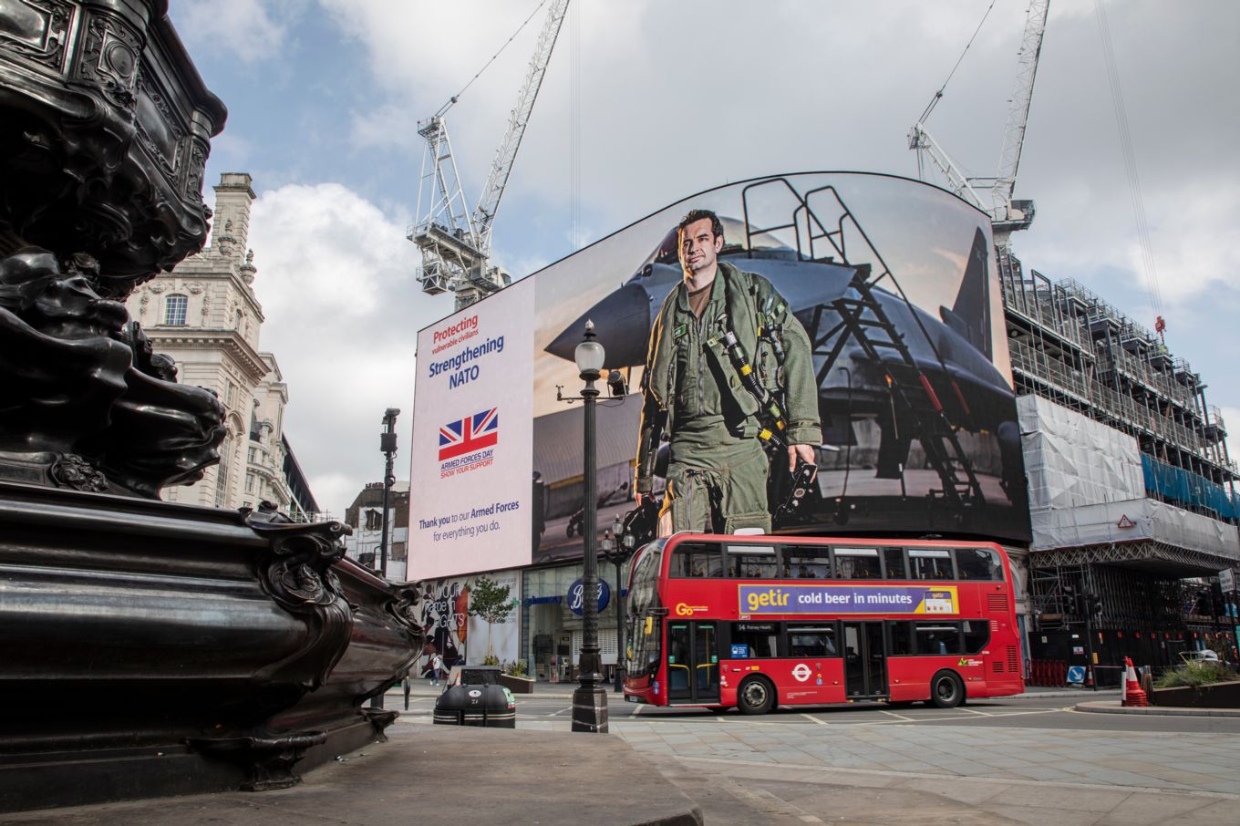 Image shows an RAF pilot on the advertisement screen at Piccadilly Circus in London.