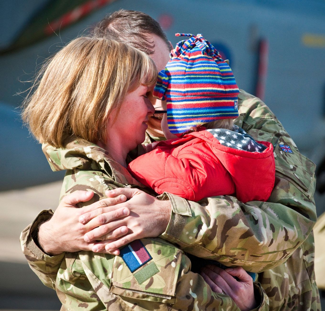 Image shows RAF personnel hugging their family.