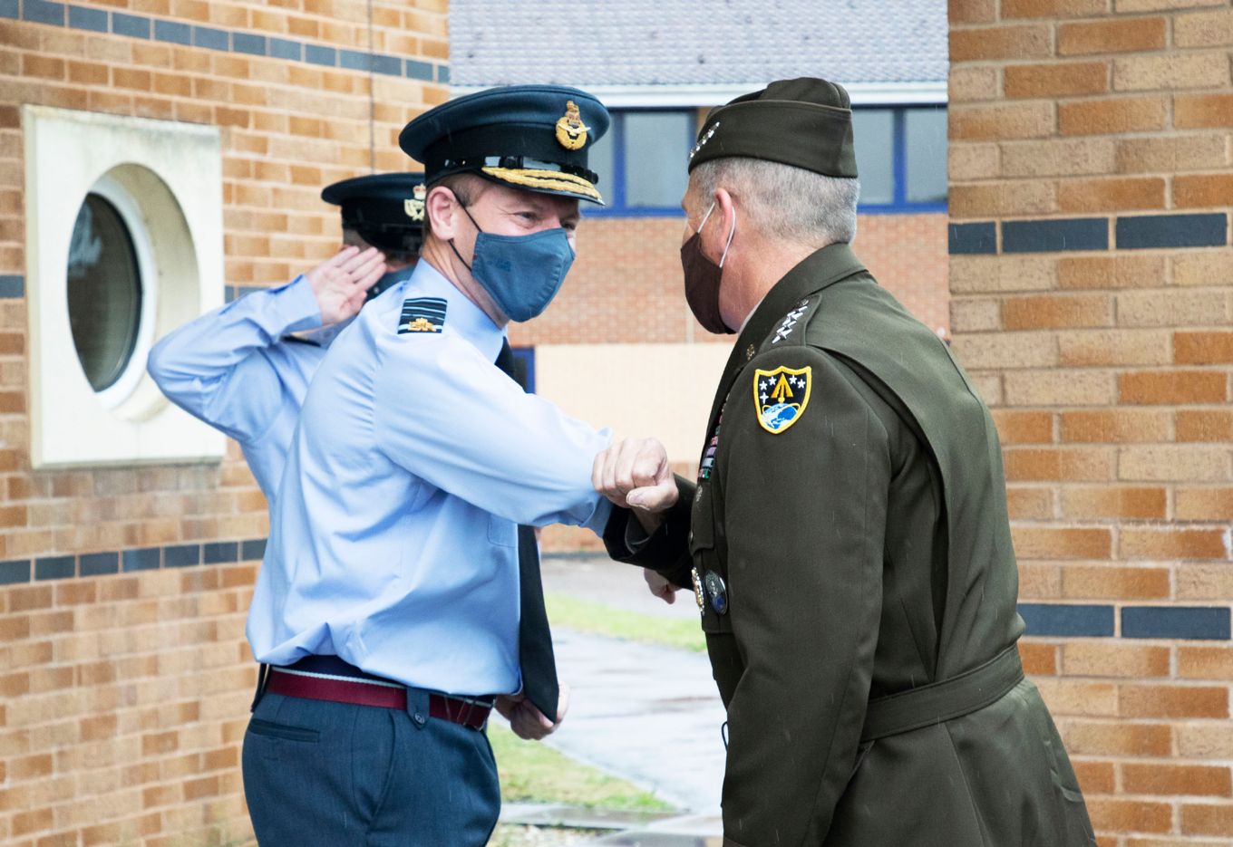General James H. Dickinson and Chief of the Air Staff, Air Chief Marshal Sir Mike Wigston touch elbows.