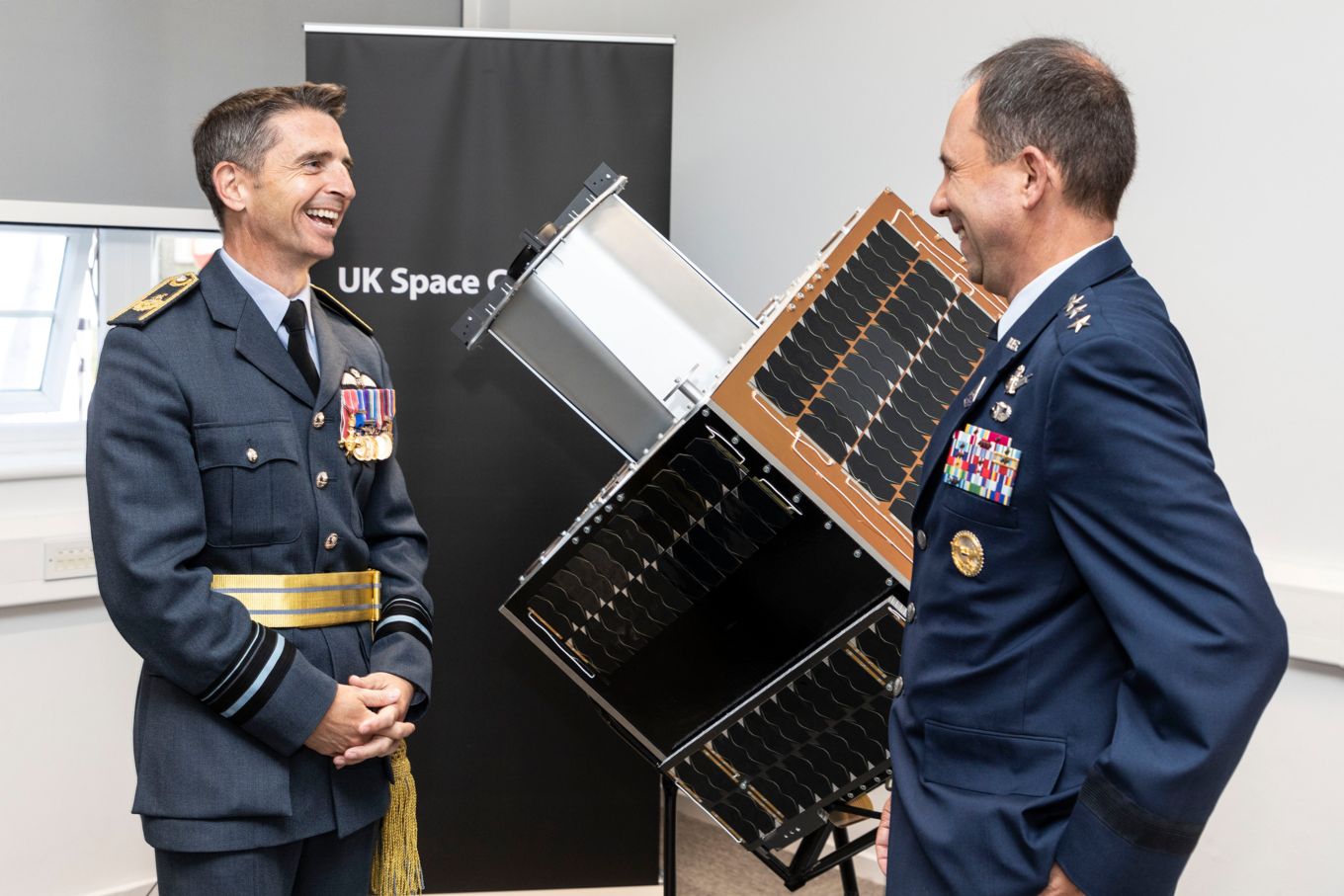 Air Vice-Marshal Paul Godfrey and Lieutenant General John Shaw stand by satellite model. 