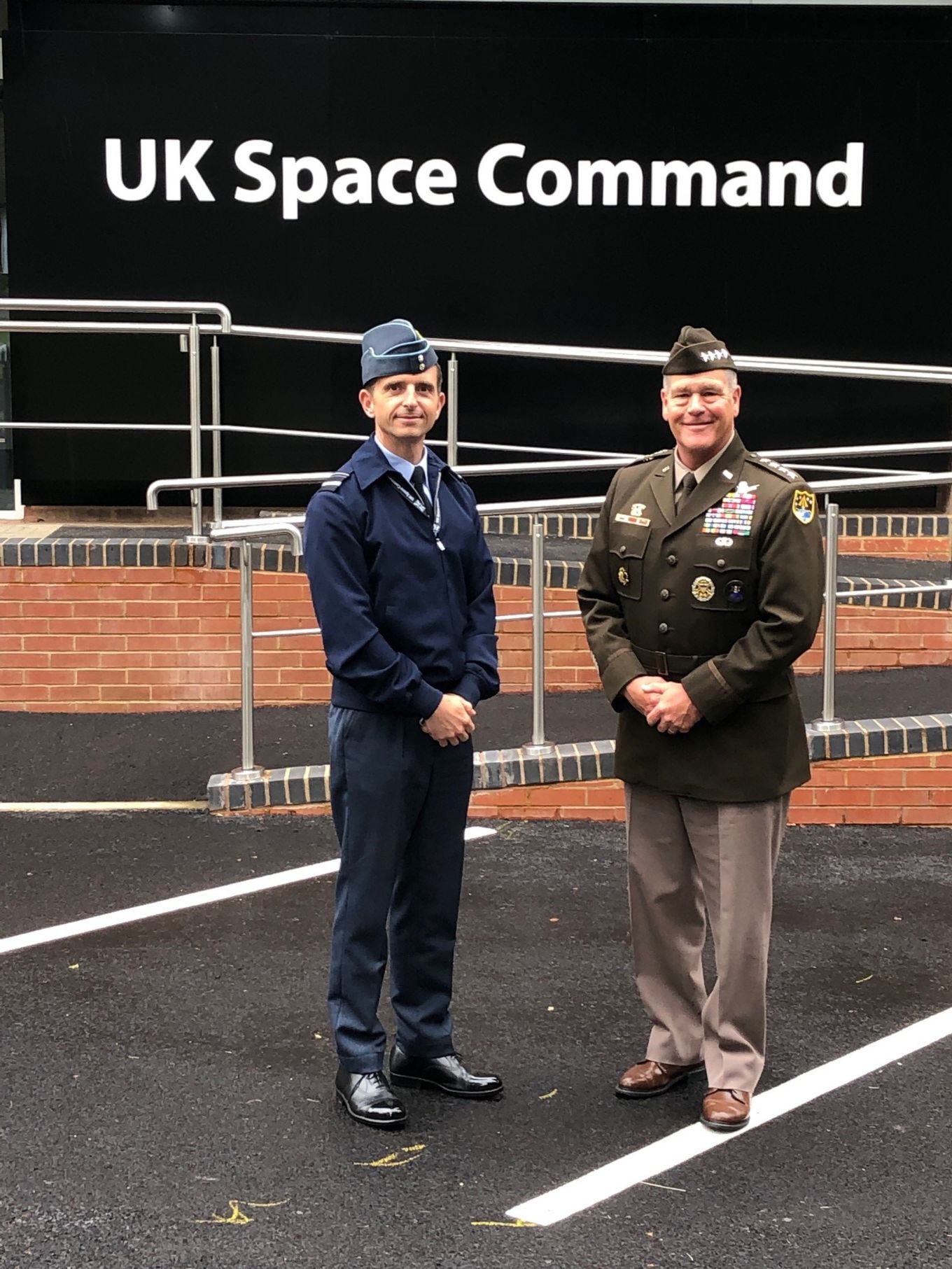 General James H. Dickinson and Air Vice-Marshall Paul Godfrey stand outside the headquarters of UK Space Command.