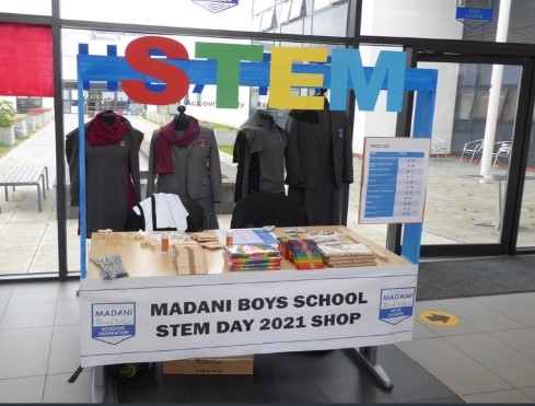 STEM stall with school uniforms and goods to buy displayed.