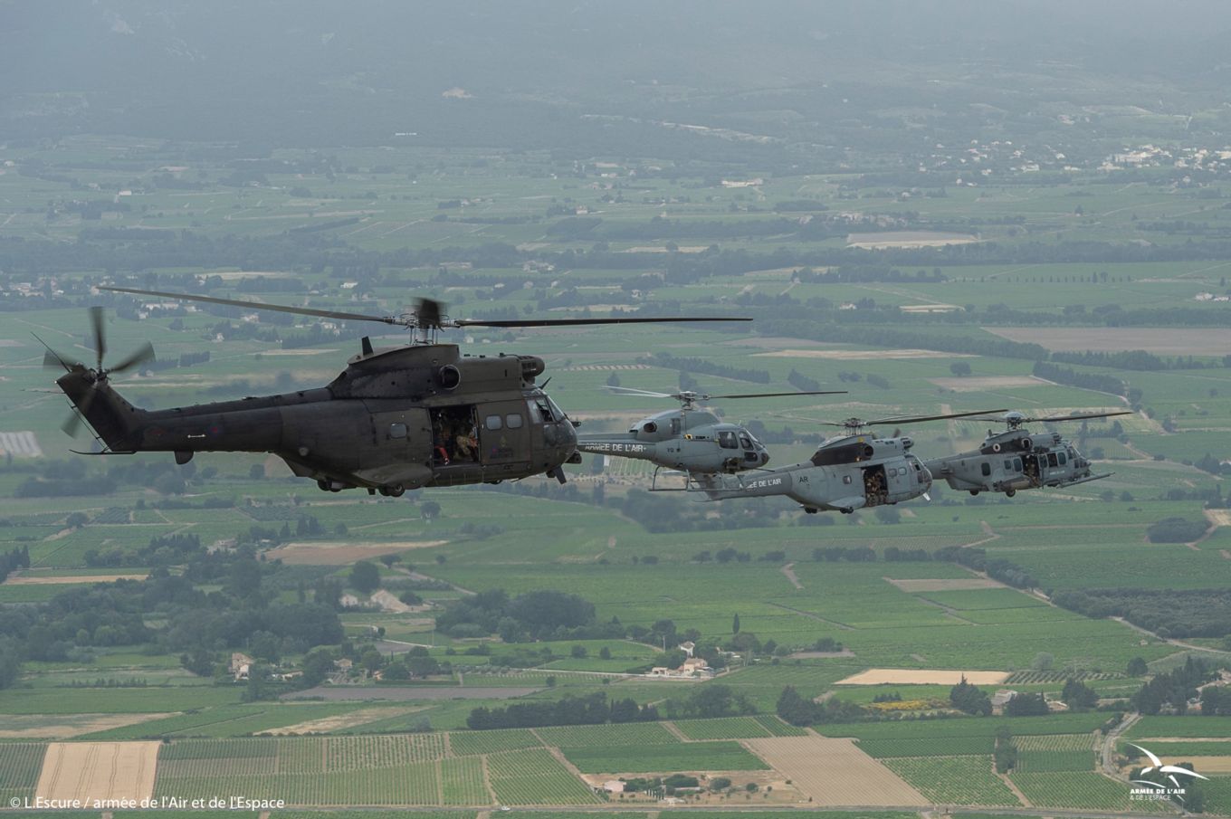 The Puma flies over the French countryside in formation with three French Air Force helicopters