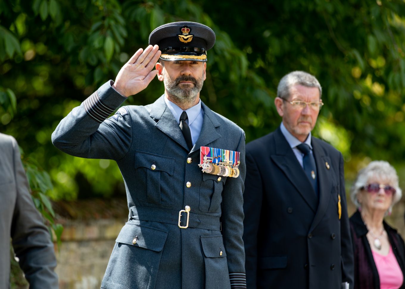RAF Honington Station Commander Gp Capt Dutch Holland takes the salute at the memorial for Wg Cdr Nigel Elsdon