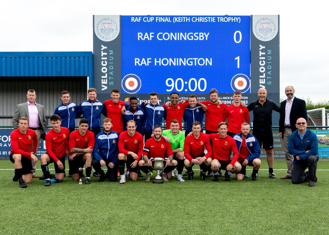 The Winning Team with the Keith Christie Trophy in front of the scoreboard