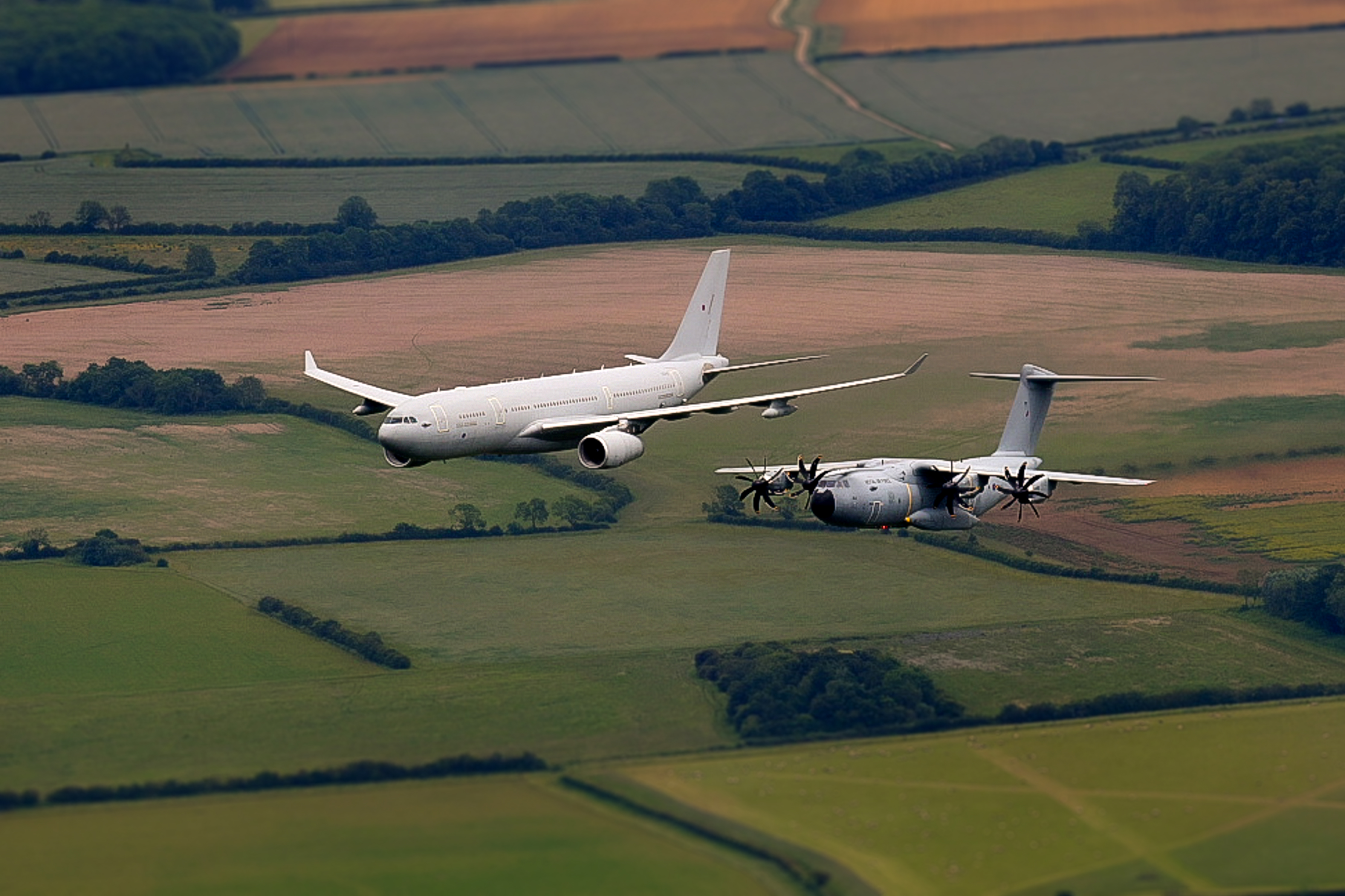 Image shows an RAF Voyager and RAF A400M Atlas flying in formation.