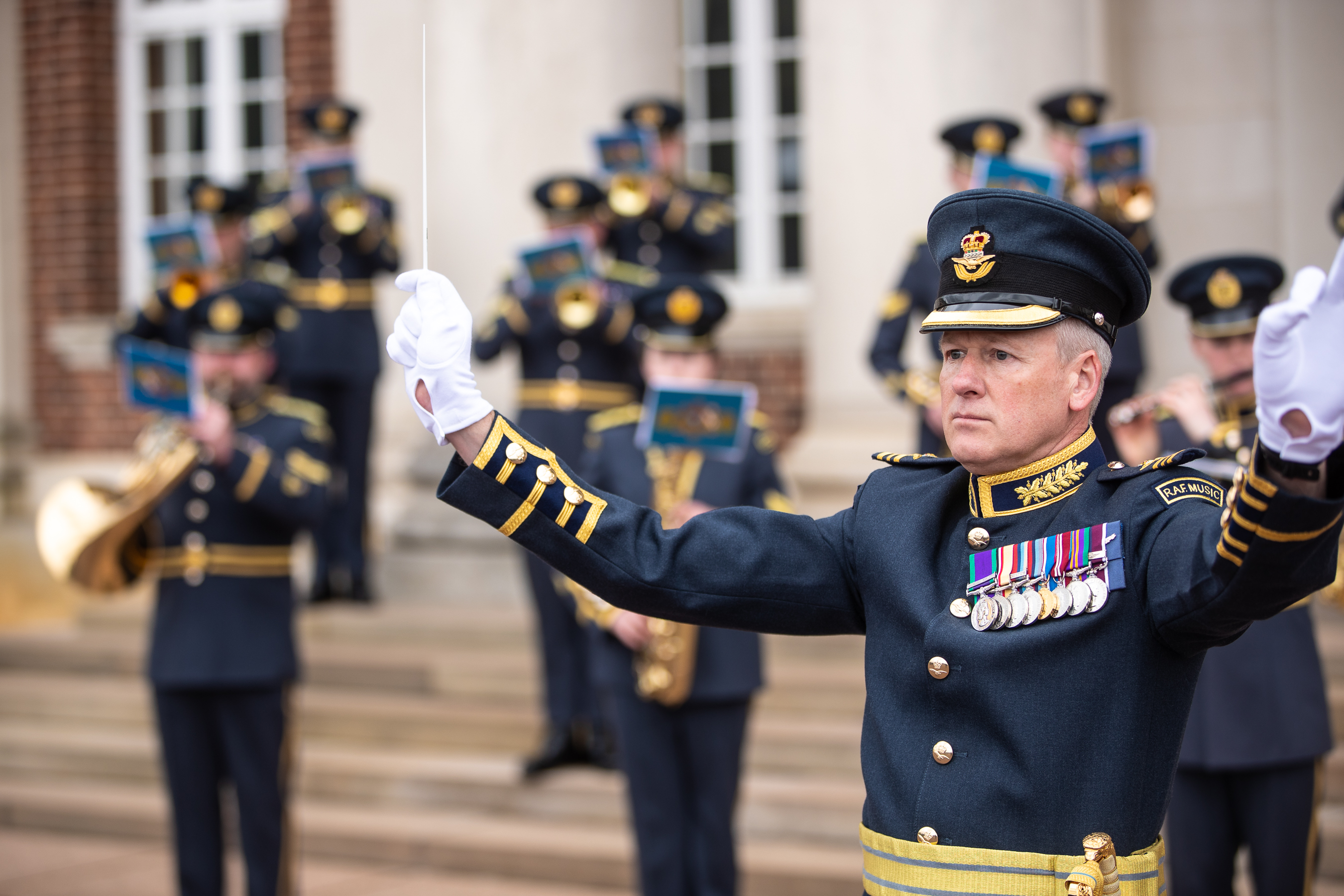 Band of the Royal Auxiliary Air Force performing outside, focused on the band conductor