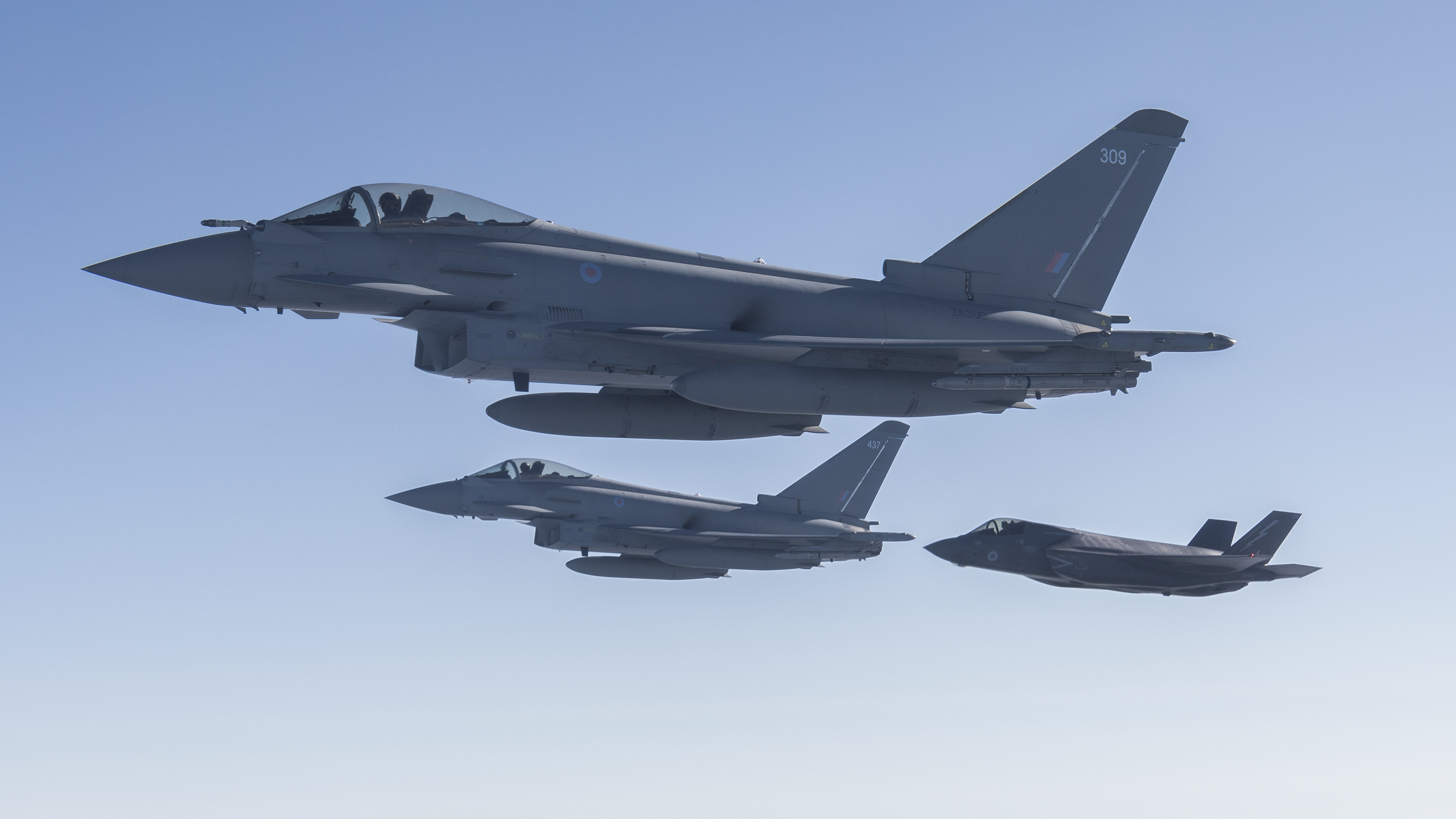 Image shows two RAF Typhoons flying with an RAF F-35.