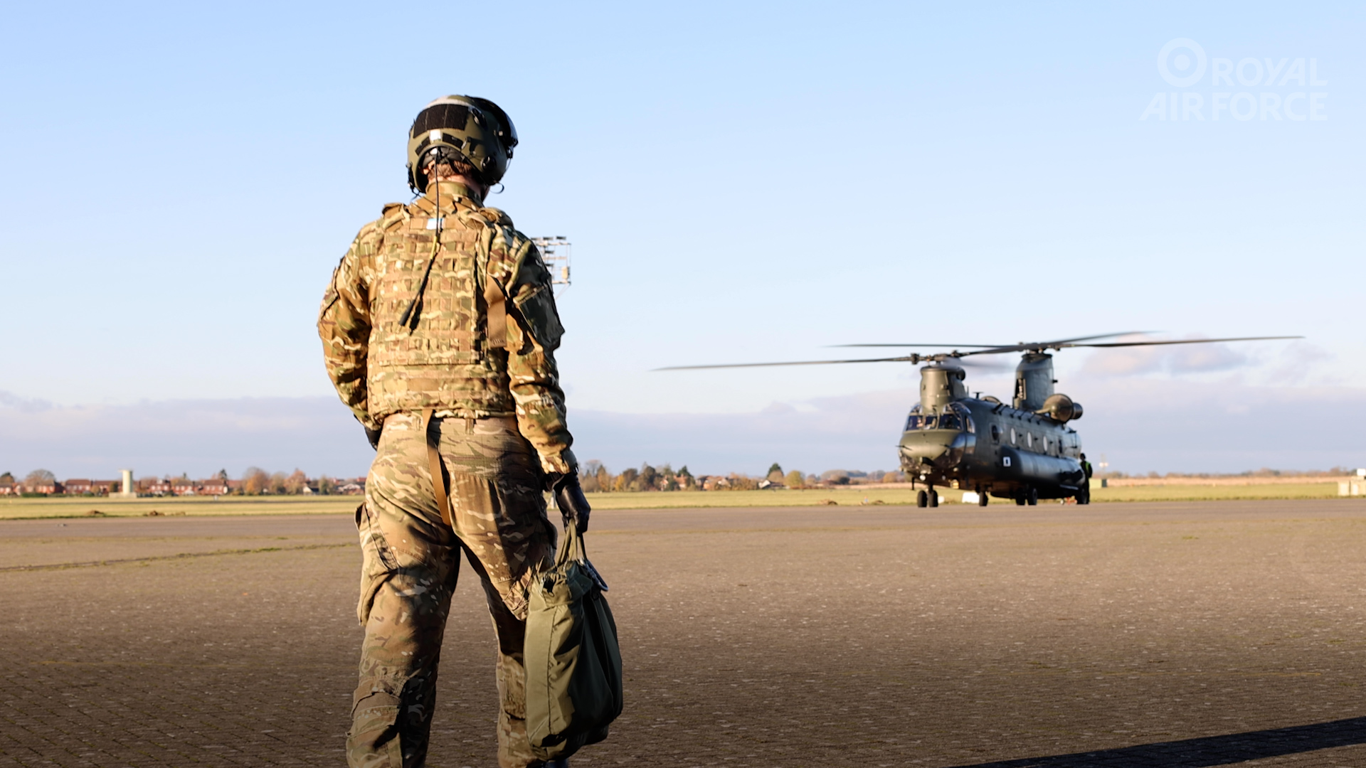 Royal Air Force pilot walking towards a waiting RAF Chinook. 