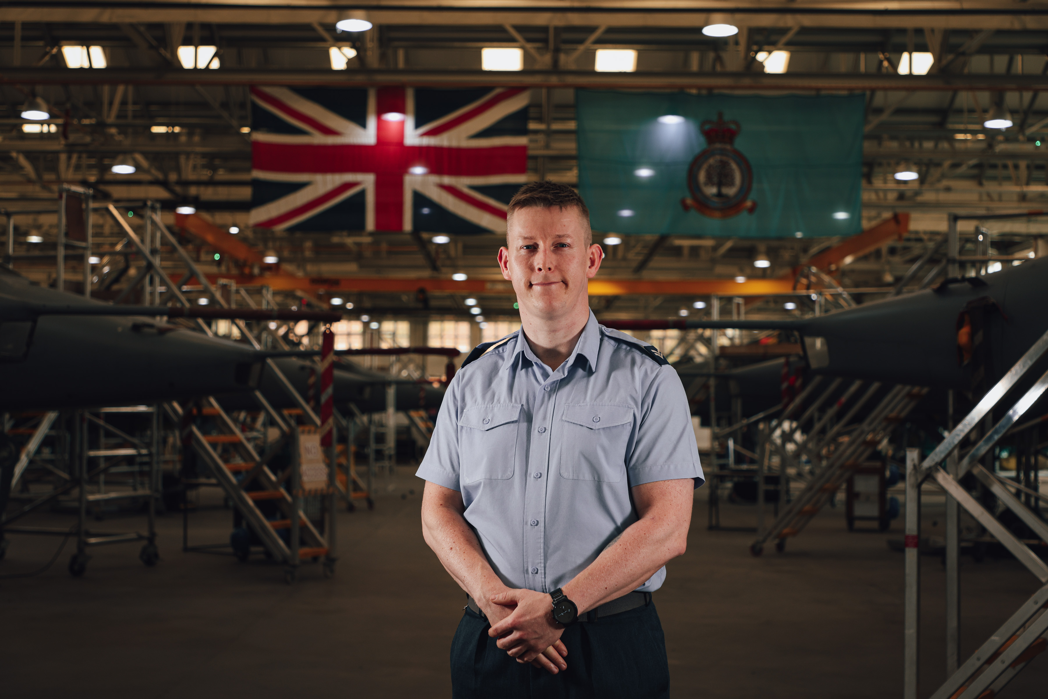 Cpl John Stanbridge stood in front of rows of Jaguar Aircraft within Number 1 School of Technical Training.