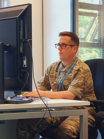 AS1 Olly Warren sat at a desk in his reservists role