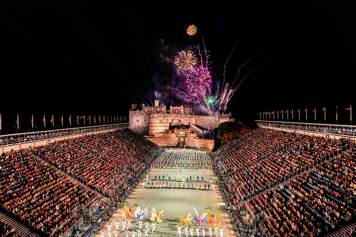 Full arena outside Edinburgh Castle at night with fireworks display in background