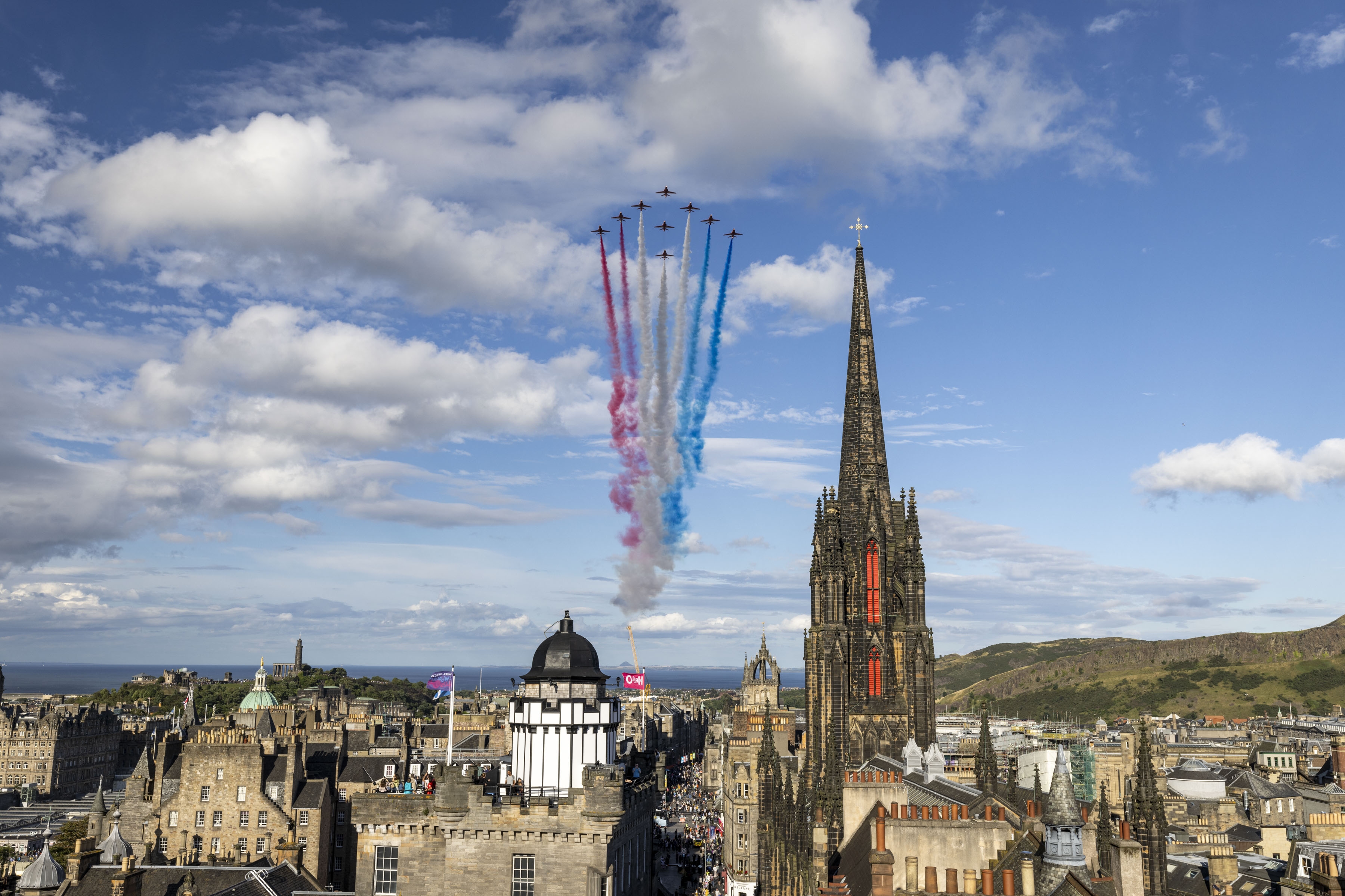 Red Arrows fly over Edinburgh with red white and blue smoke