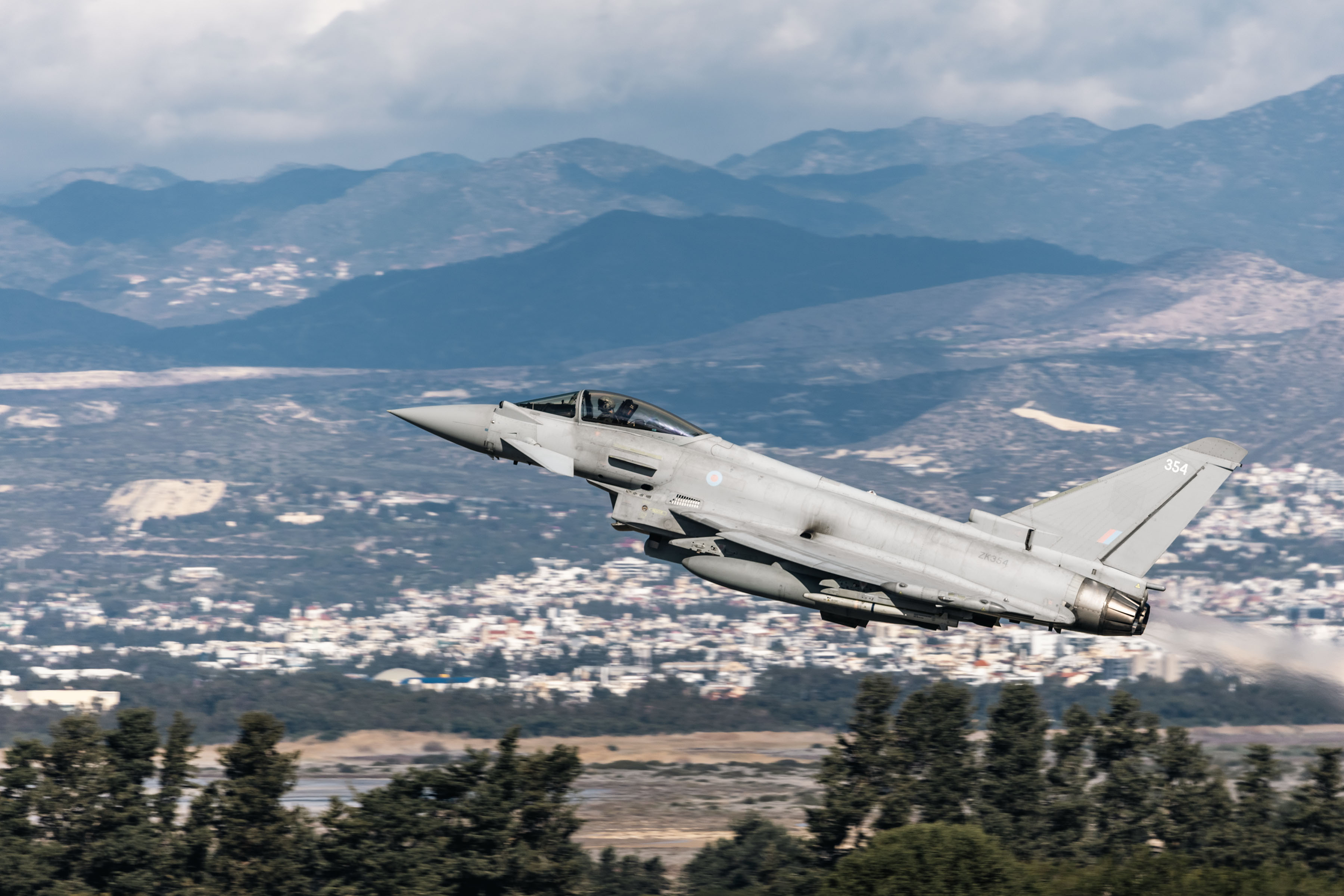 Typhoon taking off with mountains in the background