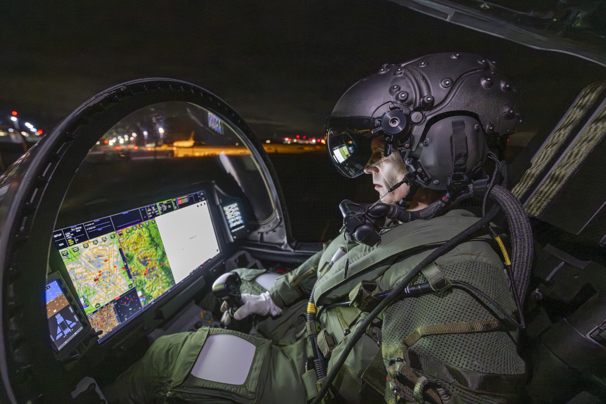 Image shows pilot wearing helmet in an aircraft